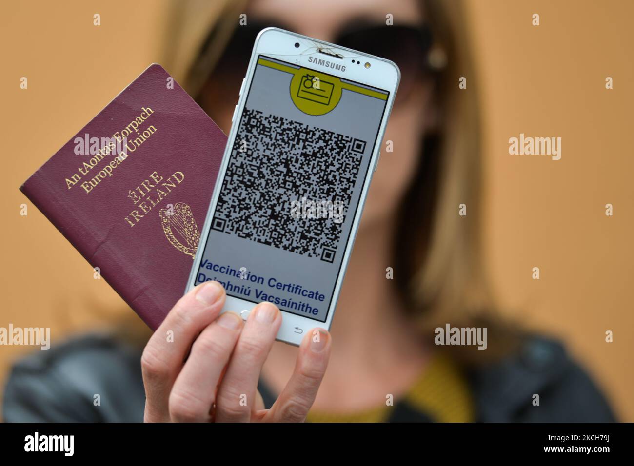 Una donna è in possesso di un passaporto irlandese e di un telefono cellulare con il certificato COVID digitale UE visualizzato sullo schermo. I certificati digitali Covid-19 sono stati inviati al pubblico questa settimana in Irlanda. Martedì 13 luglio 2021 a Dublino, Irlanda. (Foto di Artur Widak/NurPhoto) Foto Stock