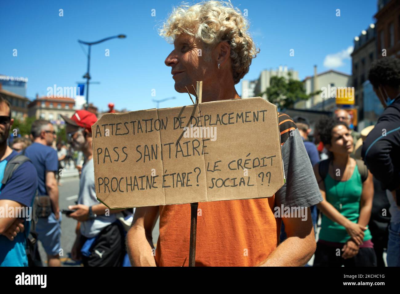 Un uomo ha un cartello che legge 'certificato di movimento, tessera sanitaria, prossima fermata? credito sociale ?' Migliaia di persone hanno protestato a Tolosa e altrove in Francia contro la vaccinazione quasi obbligatoria e contro il pass sanitario dopo il discorso di Macron del 12th luglio. Macron ha annunciato che il tessera sanitaria sarà obbligatoria per andare in luoghi pubblici come caffè, teati, sala concerti, negozi, mezzi pubblici (treno, Autobus, tram), ecc. il ritardo tra il primo jab e l'oblazione del pass sanitario sarà di cinque settimane. Ma il divieto di spazi pubblici per le persone non vaccinate continuerà Foto Stock