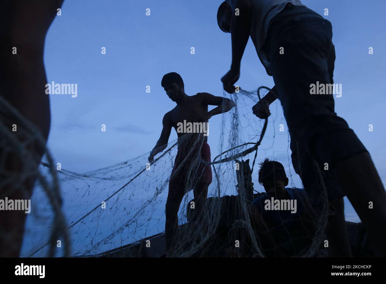 Le persone colpite dal clima stanno lavorando in una serata di scarpe da pesca del giorno a Monpura a Bhola, Bangladesh, il 18 luglio 2021. Le aree costiere del Bangladesh sono in prima linea nel cambiamento climatico, direttamente colpite da picchi di tempeste, congestione del drenaggio e aumento del livello del mare. La maggior parte del Bangladesh si trova a meno di dieci metri sul livello del mare, con quasi il dieci per cento del paese al di sotto dei 1 metri, il che lo rende estremamente vulnerabile alle alte maree in aumento. (Foto di Kazi Salahuddin Razu/NurPhoto) Foto Stock