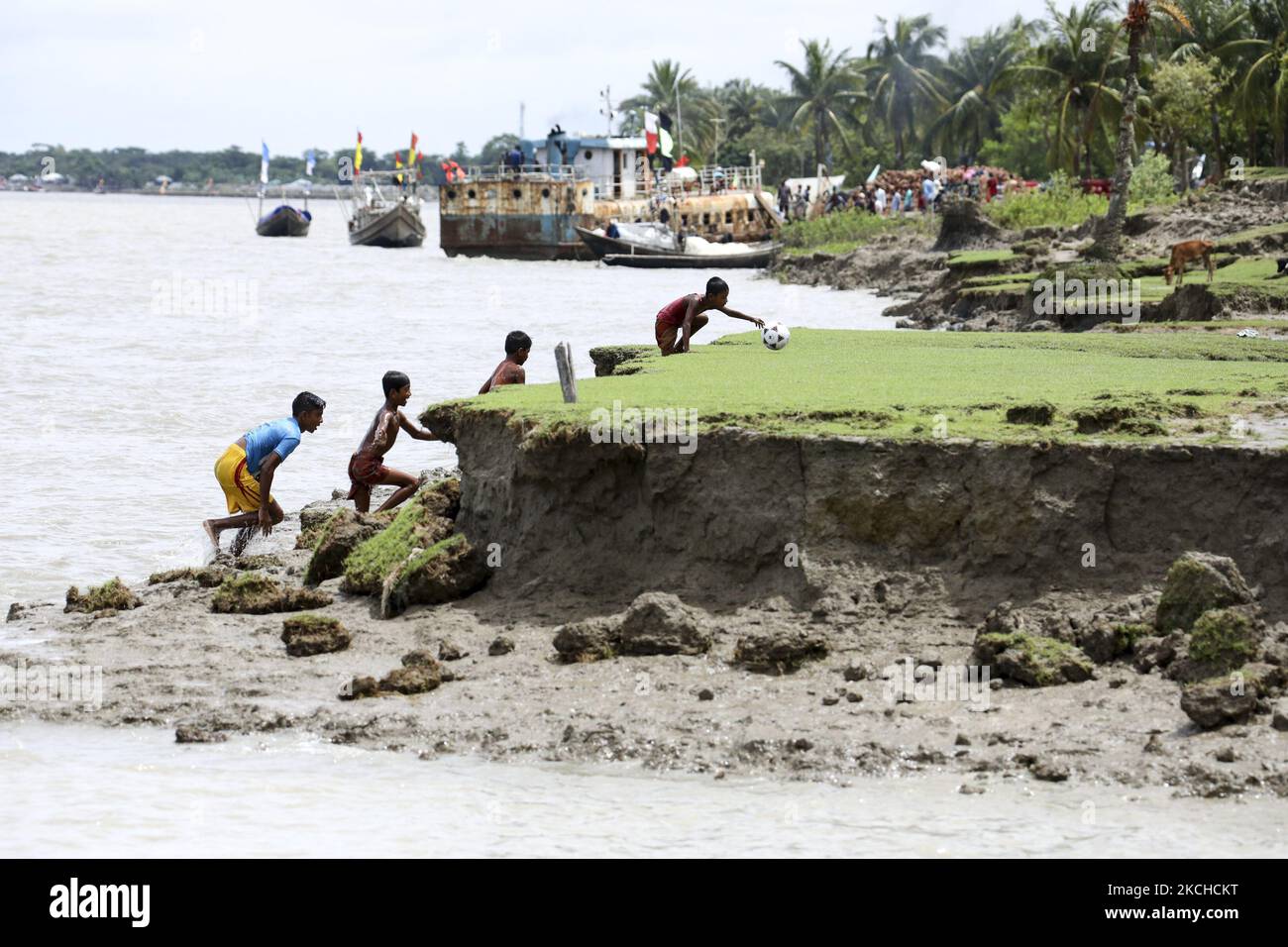 I bambini giocano a calcio in una zona colpita dal clima a Monpura a Bhola, Bangladesh, il 18 luglio 2021. Le aree costiere del Bangladesh sono in prima linea nel cambiamento climatico, direttamente colpite da picchi di tempeste, congestione del drenaggio e aumento del livello del mare. La maggior parte del Bangladesh si trova a meno di dieci metri sul livello del mare, con quasi il dieci per cento del paese al di sotto dei 1 metri, il che lo rende estremamente vulnerabile alle alte maree in aumento. (Foto di Kazi Salahuddin Razu/NurPhoto) Foto Stock