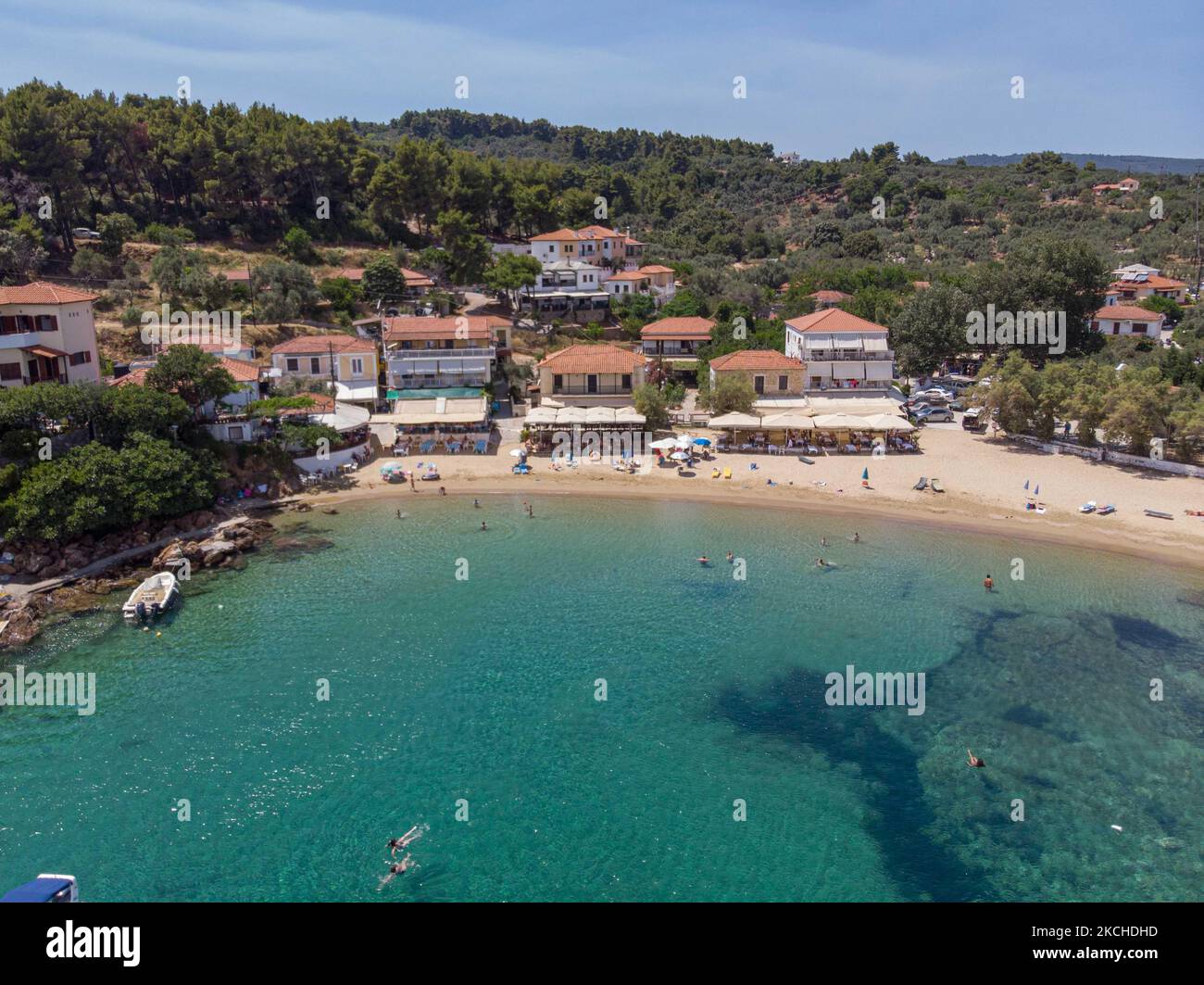 Vista aerea panoramica da un drone di Agios Giorgios o Katigiorgis Village, spiaggia e porto nella regione di Pelion in Grecia con sole durante il periodo estivo. Katigiorgis è un pittoresco villaggio di pescatori a 61km km dalla città di Volos e a 3 miglia nautiche dall'isola di Skiathos che offre una facile opzione per i turisti di visitare le isole Skiathos e Sporades o Pelion con il traghetto. Questo villaggio è piccolo, bello, tranquillo e tranquillo, un paradiso appartato nel Mediterraneo mantenendo il suo stile originale con persone calde, circondato da vegetazione lussureggiante, uliveti e basse colline che hanno solo alcune opzioni per l'ac Foto Stock