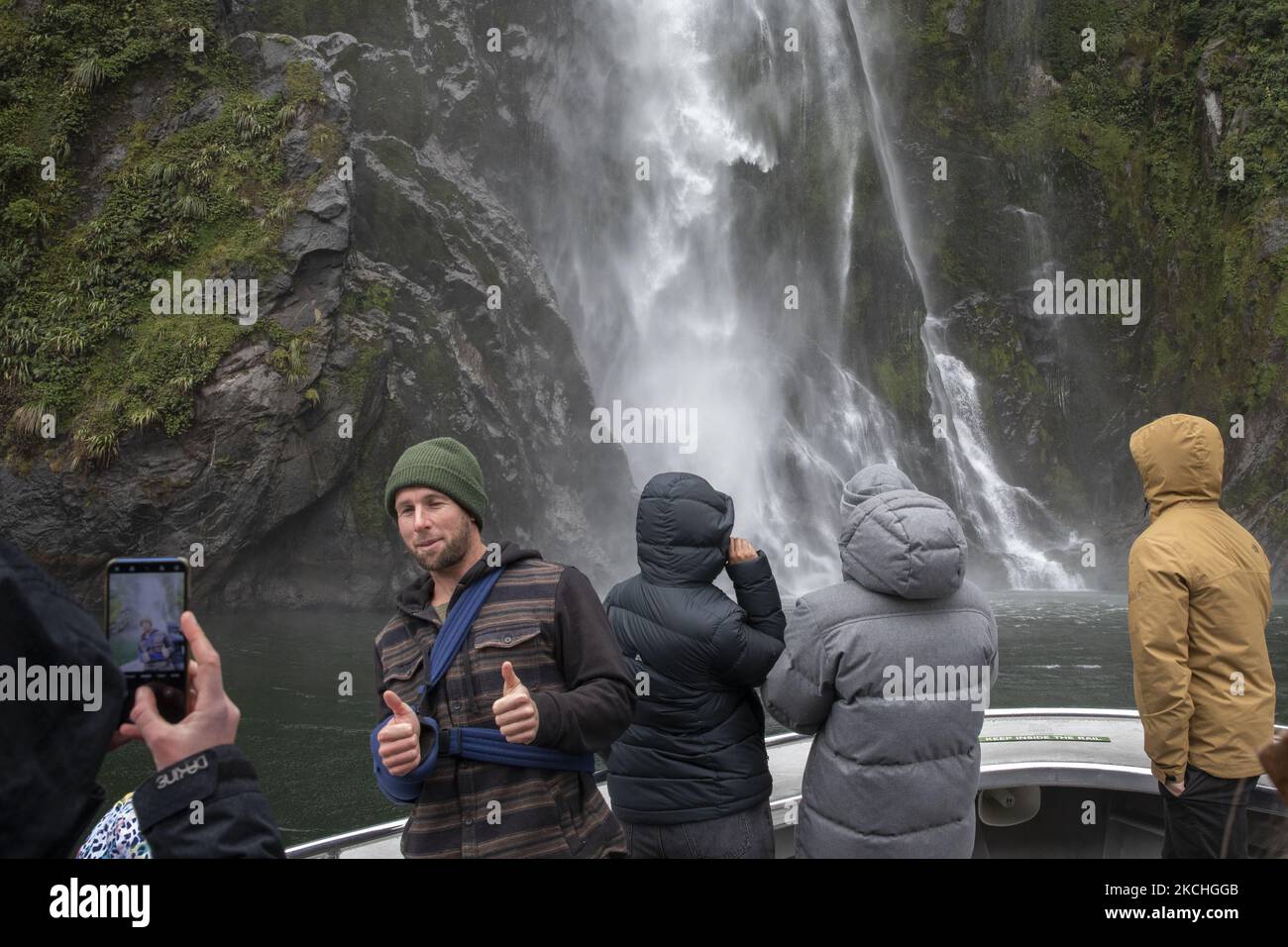 Il 22 luglio 2021 i visitatori potranno scattare foto di fronte allo Stirling Falls Milford Sound, nella parte sud-occidentale del Fiordland National Park, Nuova Zelanda. Milford Sound è un sito patrimonio dell'umanità dell'UNESCO nell'isola meridionale della Nuova Zelanda. (Foto di Sanka Vidanagama/NurPhoto) Foto Stock