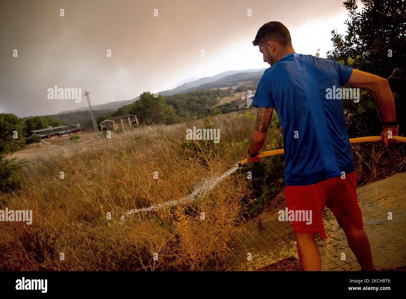 Vigili del fuoco e volontari stanno lavorando per fermare il fuoco selvaggio nelle contee di Anoia e Conca de Barberà, vicino a Barcellona il 25 e 26 luglio 2021, in Catalogna, Spagna. (Foto di Albert Llop/NurPhoto) Foto Stock
