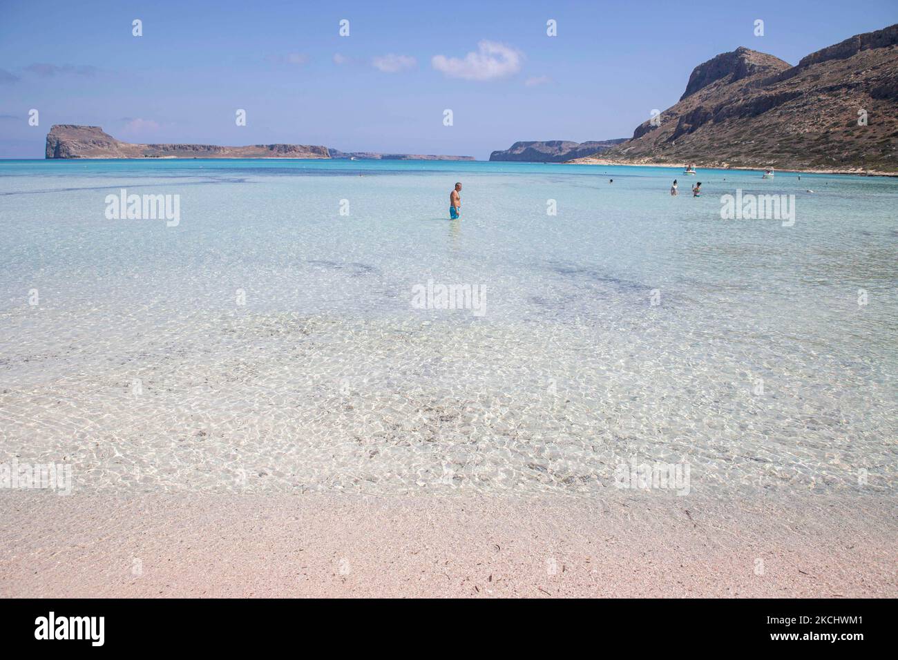 La sabbia rosa di Balos Beach, l'incredibile laguna, con la piscina come le acque turchesi esotiche e tropicali del mare Mediterraneo si trova nella regione di Chania, nell'isola di Creta. Balos è una delle spiagge più visitate di Creta e popolare per i visitatori di tutto il mondo. Acque cristalline, la laguna, montagne rocciose ripide, un bar sulla spiaggia che fornisce ombrelloni e ombra con bevande e un'isola pirata si trovano nella stessa regione che è accessibile da un trekking di 20 minuti o in barca. La Grecia sta cercando di incentivare il proprio turismo e concedere privilegi per vaccinare contro la pandemia interna di Coronavirus Covid-19 Foto Stock