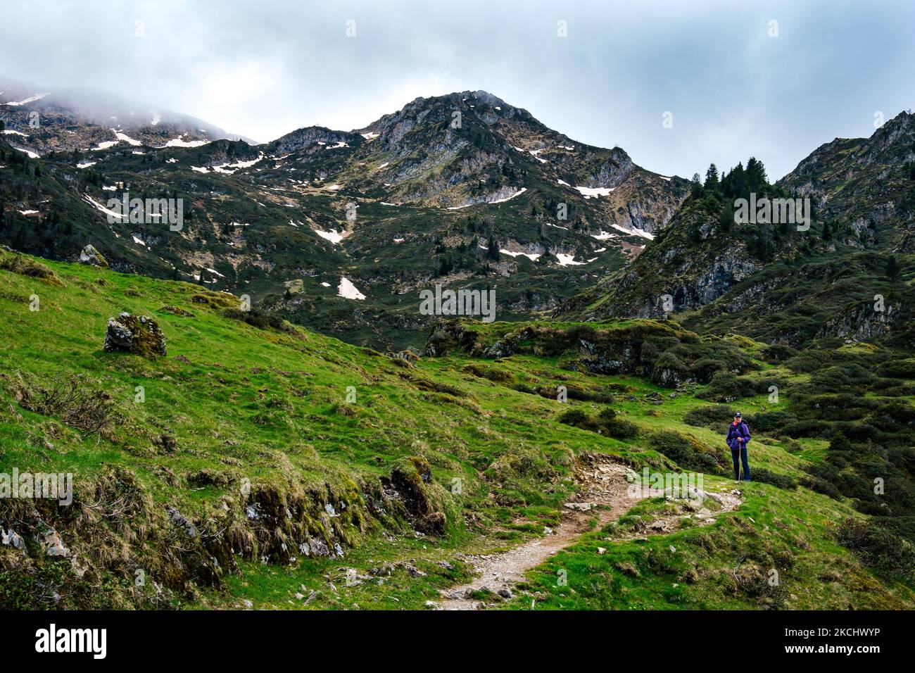 Sentiero escursionistico nei pascoli vicino al lago Ayes nella catena montuosa dei Pirenei francesi in una giornata nuvolosa Foto Stock