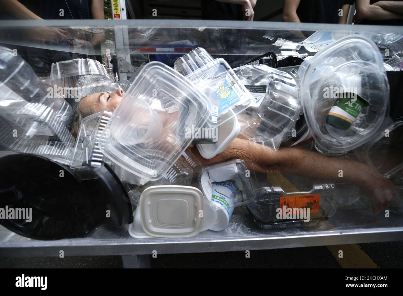 L'artista Anne-Katrin Spiess è trasportato su 5th Avenue in una bara di plastica trasparente durante una protesta per simbolizzare "Death by Plastic A Funeral Procession" il 28 luglio 2021 a New York City, USA. Il tema del rally è che “se continuiamo a usare bottiglie d’acqua usa e getta non ci sarà acqua pulita che ci sarà ancora da bere” (Foto di John Lamparski/NurPhoto) Foto Stock