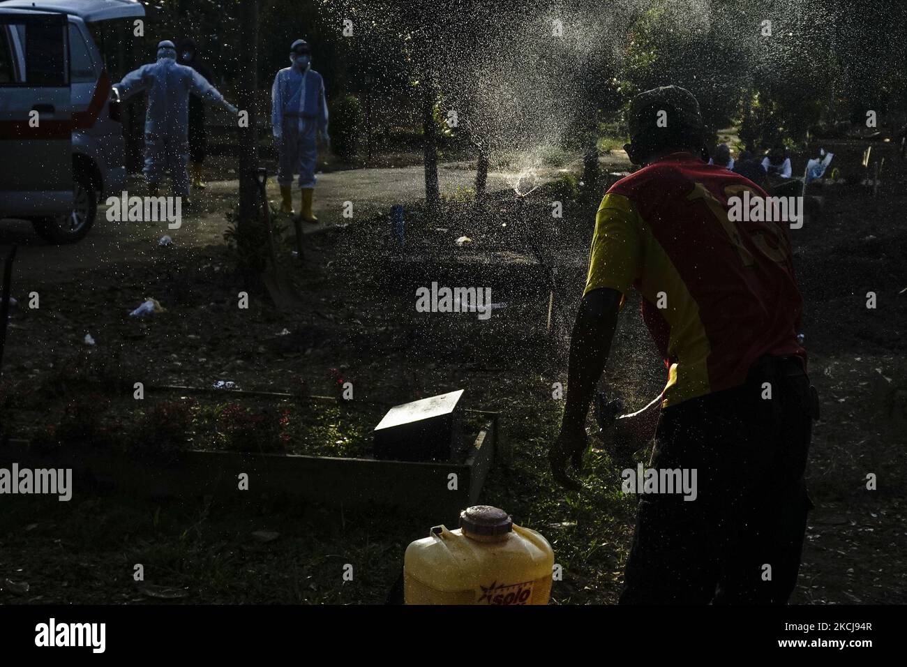 I gravediggers in un cimitero speciale per le vittime dell'epidemia di coronavirus nel cimitero di Gandus, Palembang, stanno spruzzando disinfettante dopo aver seppellito i corpi di Covid-19 il Giovedi, 5 agosto 2021. (Foto di Sigit Prasetya/NurPhoto) Foto Stock