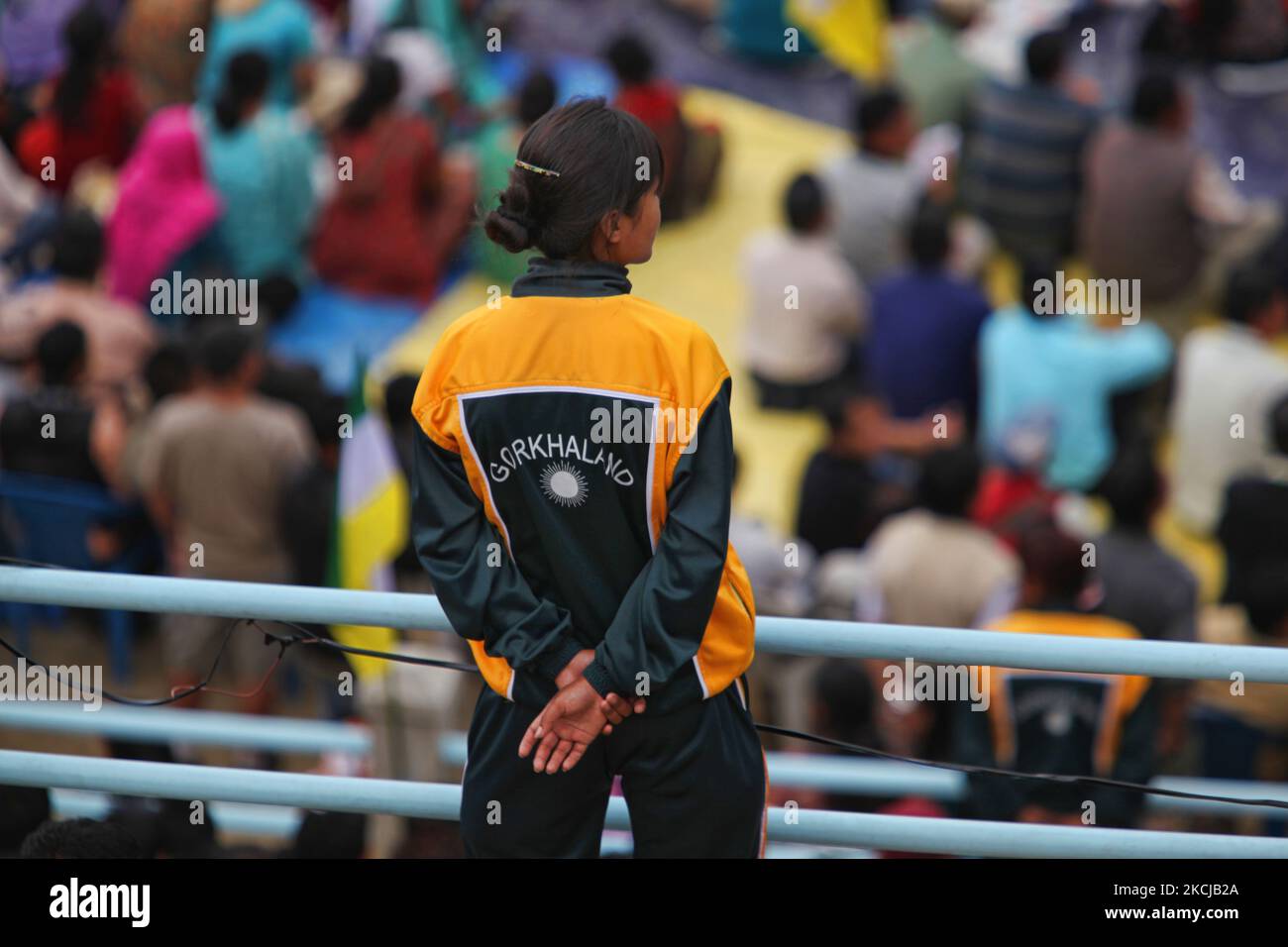 Membro della polizia di Gorkhaland vigila su migliaia di sostenitori nepalesi in un raduno mentre i politici parlano dell'importanza di raggiungere Gorkhaland durante un artal (sciopero generale) è stato chiamato che chiudere l'intera città di Darjeeling così come le città circostanti che interessano l'intera collina-stazione a Darjeeling, Bengala Occidentale, India, il 30 maggio 2010. L'artal è stato chiamato dopo Madan Tamang, leader del gruppo moderato Akhil Bharatiya Gorkha League (ABGL) è stato pugnato a morte presumibilmente da Gorkha Janmukti Morcha (GJM) sostenitori il 21 maggio 2010 a Darjeeling, che portano ad una spontanea Foto Stock