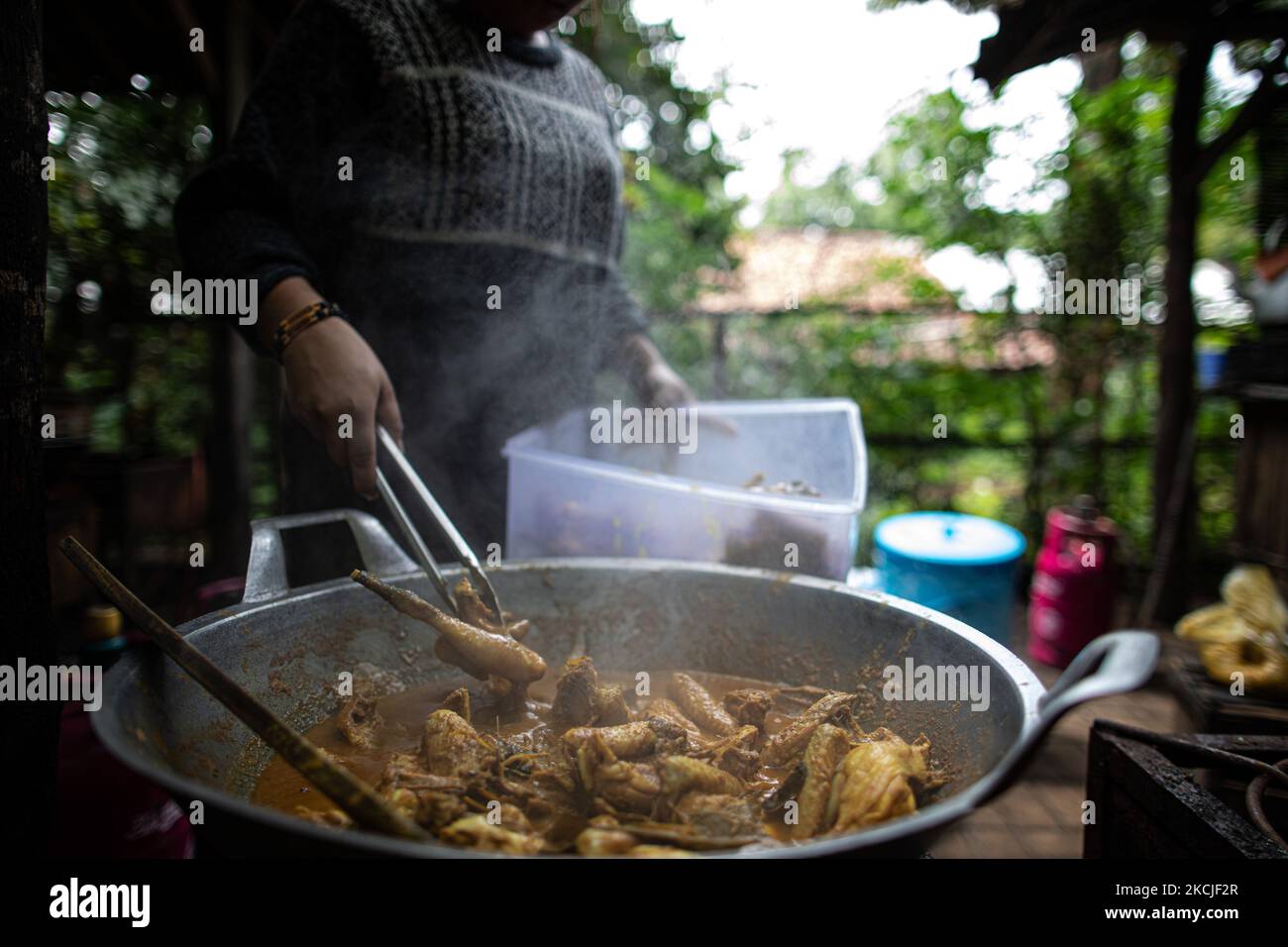 Un dipendente sta preparando il curry di pollo per i futuri clienti. Lo stallo alimentare di Tuman nel Tangerang meridionale, Banten, Indonesia ha registrato un calo del reddito fino al 40% a causa delle restrizioni sulle attività comunitarie che il governo continua a imporre per prevenire la diffusione del covid19. I nuovi decessi per COVID-19 in Indonesia sono rimasti i più alti al mondo negli ultimi 2 mesi. Il 10 agosto 2021 a Tangerang Sud, Banten, Indonesia. (Foto di Donal Husni/NurPhoto) Foto Stock