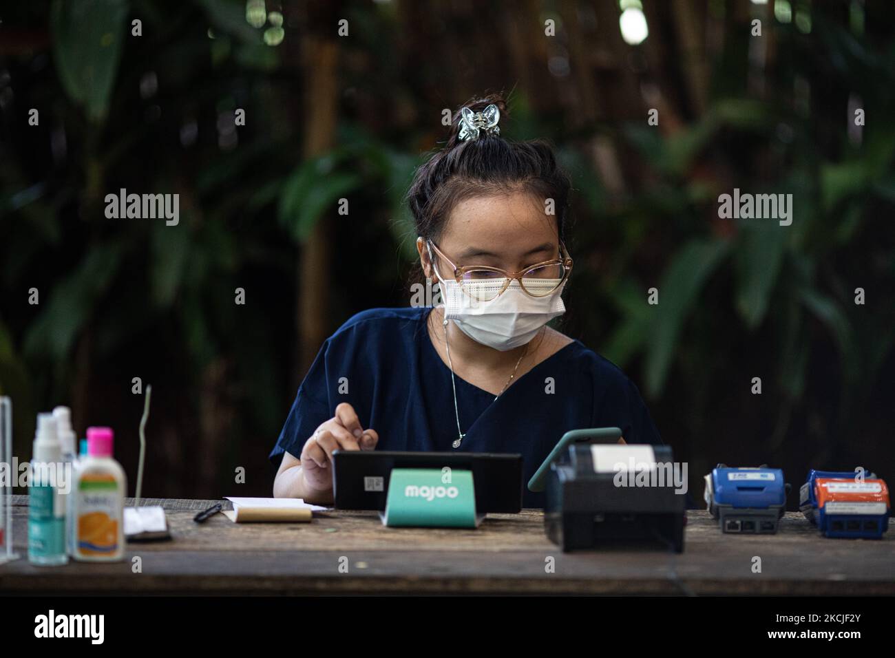 Il dipendente cassiere del tuman cibo stalla sta facendo il calcolo del reddito. Lo stallo alimentare di Tuman nel Tangerang meridionale, Banten, Indonesia ha registrato un calo del reddito fino al 40% a causa delle restrizioni sulle attività comunitarie che il governo continua a imporre per prevenire la diffusione del covid19. I nuovi decessi per COVID-19 in Indonesia sono rimasti i più alti al mondo negli ultimi 2 mesi. Il 10 agosto 2021 a Tangerang Sud, Banten, Indonesia. (Foto di Donal Husni/NurPhoto) Foto Stock