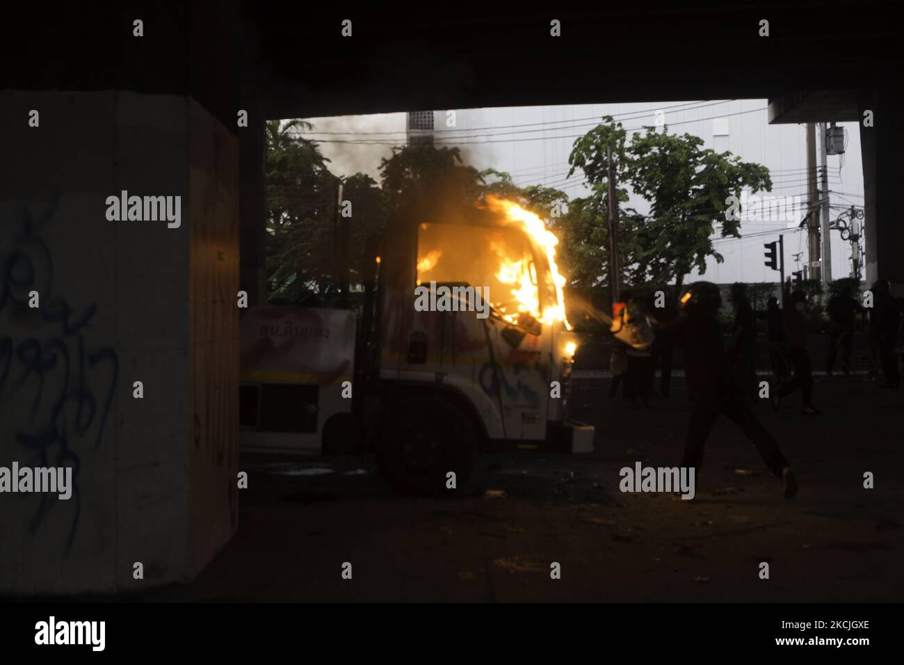 I dimostranti spruzzano benzina su una macchina della polizia in fiamme. Il 11 agosto 2021 a Bangkok, Thailandia. (Foto di Atiwat Siltamethanont/NurPhoto) Foto Stock