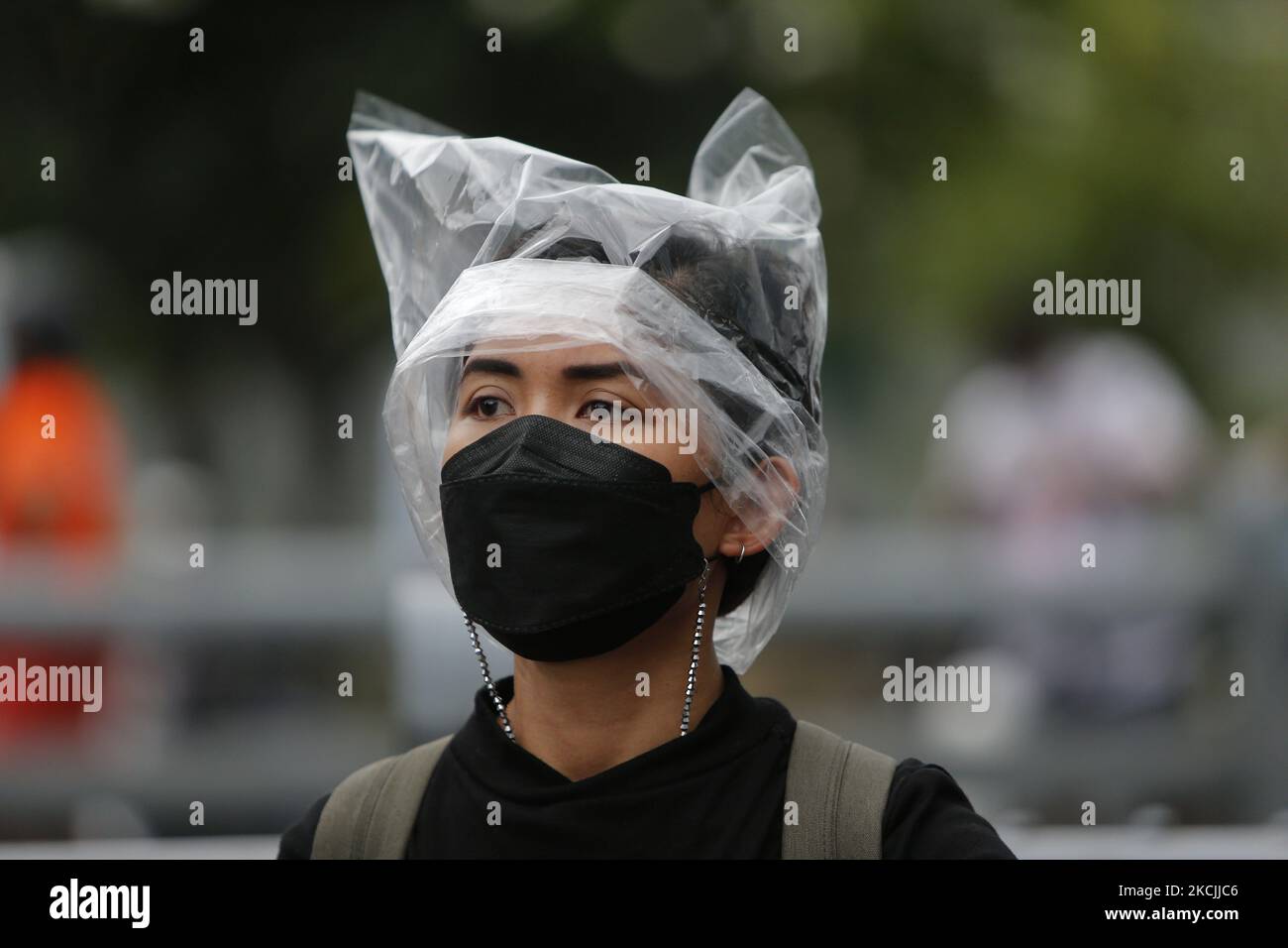 I manifestanti la coprono con una borsa di plastica durante la manifestazione a Bangkok il 13 agosto 2021. La polizia di Bangkok ha sparato proiettili di gomma e gas lacrimogeni contro i manifestanti pro-democrazia che chiedevano al primo ministro, Prayut Chan-o-cha di scendere e il governo di essere ritenuto responsabile per la sua cattiva gestione della pandemia del Covid-19. (Foto di Chaiwat Subprasom/NurPhoto) (Foto di Chaiwat Subprasom/NurPhoto) Foto Stock