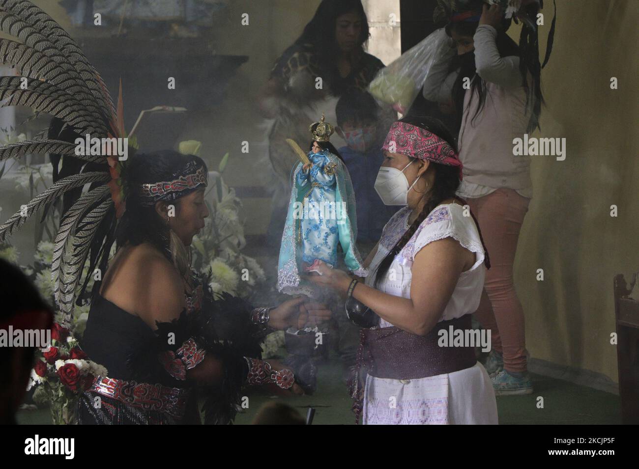 Una ballerina pre-ispanica all'interno della parrocchia dell'Assunzione di Maria situata a Milpa alta, Città del Messico, conserva l'immagine della Vergine dell'Assunzione durante la commemorazione di 500 anni di resistenza indigena e invasione spagnola in Messico, dove ballerini, cantanti, e i guaritori hanno condiviso le loro conoscenze e onorato i loro antenati, con lo scopo di avvicinare i cittadini a riflettere sulla loro storia e identità. (Foto di Gerardo Vieyra/NurPhoto) Foto Stock