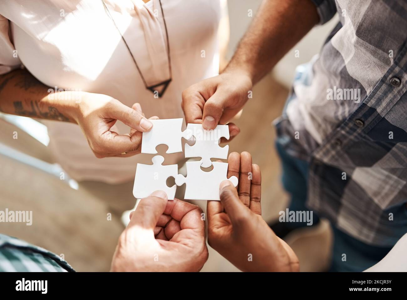 Il lavoro di squadra si occupa della risoluzione dei problemi. Un gruppo di creativi che collegano pezzi di un puzzle. Foto Stock