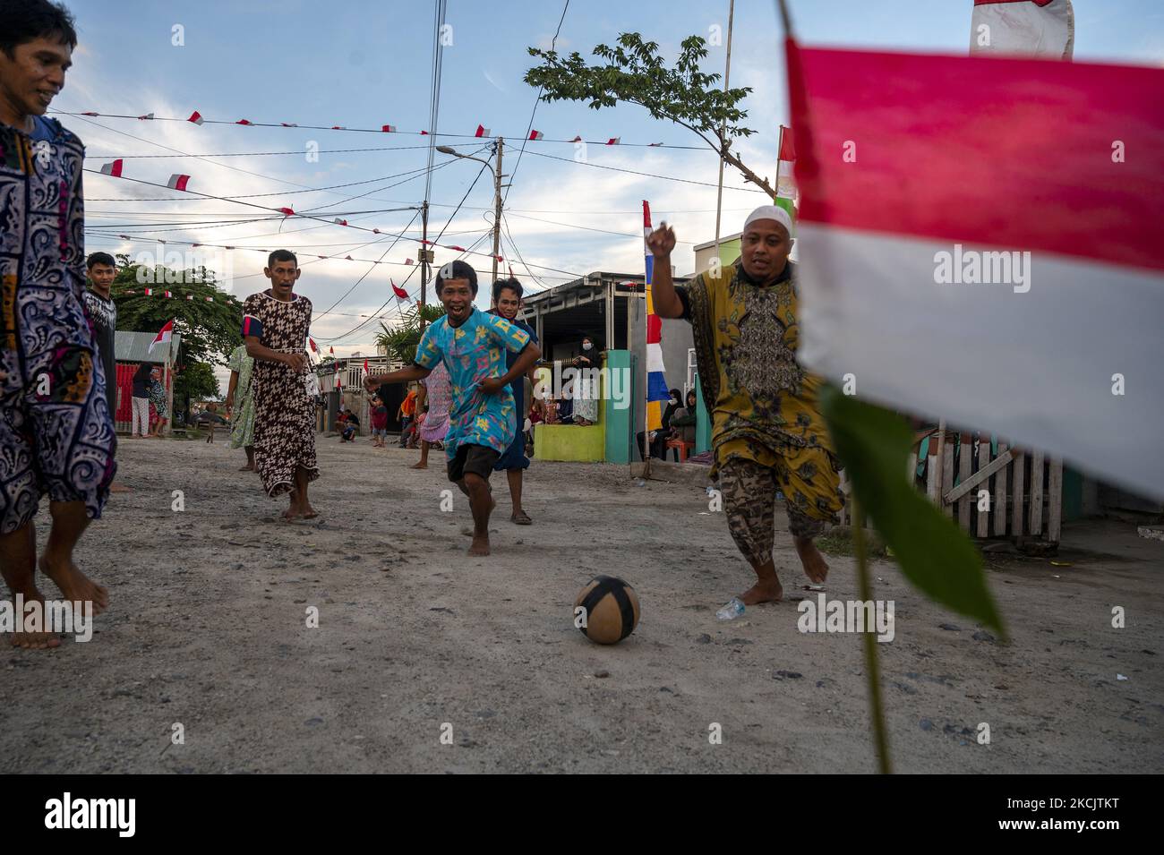 I residenti giocano a 'dangdut ball' per commemorare il 76th° giorno dell'Indipendenza della Repubblica di Indonesia in un complesso residenziale nel villaggio di Boya Baliase, nella reggenza di Sigi, nella provincia centrale di Sulawesi, in Indonesia il 17 agosto 2021. 'Dangdut ball' è un gioco di calcio giocato da uomini con una negligenza e accompagnato da canzoni ritmiche malesi e i giocatori devono ballare quando la canzone è cantata. Nonostante la pandemia del COVID-19, i residenti che vivono nella zona verde celebrano ancora la Giornata dell'Indipendenza con varie attività di intrattenimento. (Foto di Basri Marzuki/NurPhoto) Foto Stock