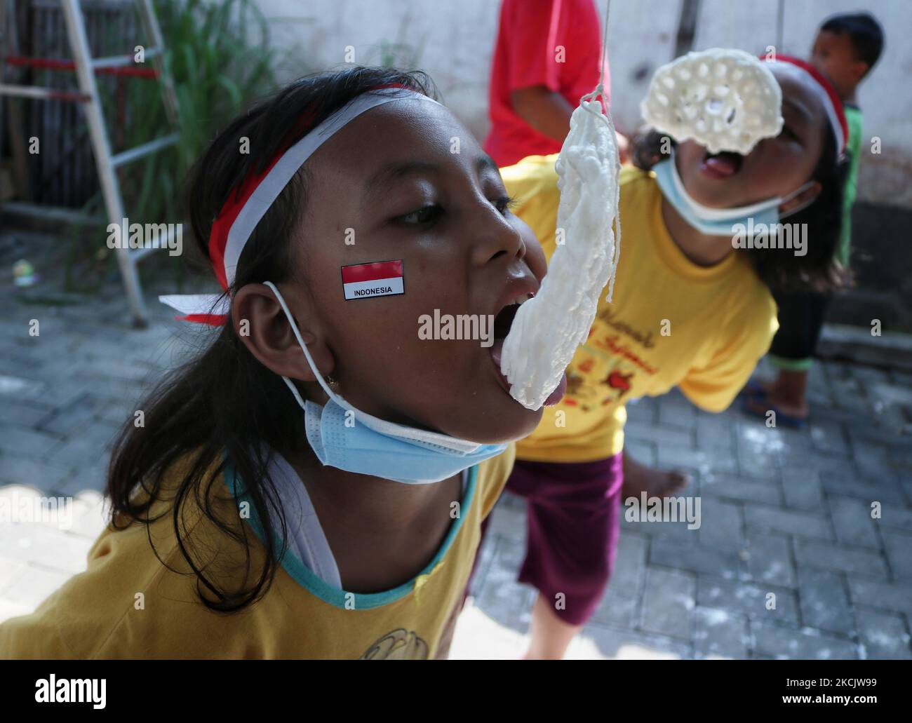 Diversi bambini sono in competizione il gioco tradizionale per bambini (eat cracker), mentre celebrare il 76th ° giorno di indipendenza indonesiana nel cortile di Pandawangi Village, Malang, Giava orientale, Indonesia, nel mese di agosto 17, 2021.il popolo indonesiano riuscì a combattere per l'indipendenza il 17 agosto 1945 dal coloniale olandese per 350 anni e la colonizzazione giapponese per 3,5 anni. (Foto di Aman Rochman/NurPhoto) Foto Stock