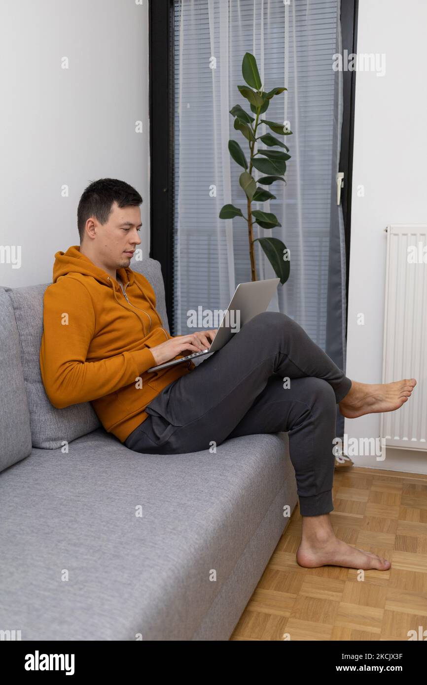 giovane uomo che guarda al notebook giocando Foto Stock