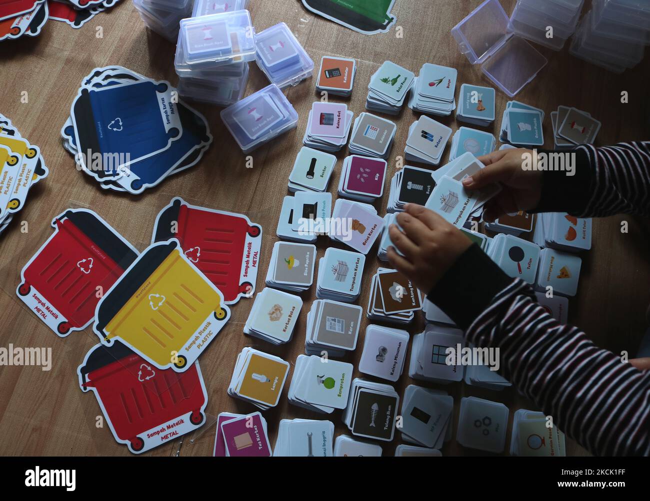 Diverse lavoratrici fanno i giochi educativi dei bambini dalla carta (marchio Wuffy Land) con il tema 'ambiente di amore' e li commercializzano all'estero attraverso e-commerce, Facebook, e Instagram presso l'industria domestica a Malang, Java orientale, Indonesia, 20 agosto 2021. L'artigiano vende prodotti di prezzo variabile da $1,38 a $5,80 per unità e la produzione raggiunge 7000 unità al mese. È stato commercializzato in Malesia, Singapore e negli Stati Uniti attraverso il commercio elettronico. (Foto di Aman Rochman/NurPhoto) Foto Stock