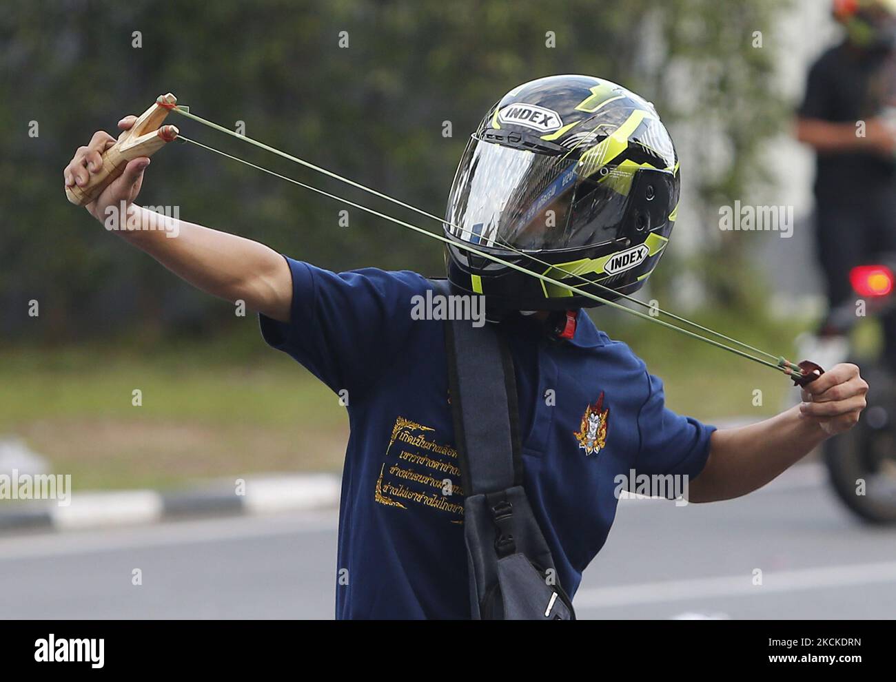 Un manifestante usa un colpo di slingshot per lanciare una pietra contro poliziotti tumulto durante la manifestazione a Bangkok il 29 agosto 2021. I manifestanti che chiedono al primo ministro thailandese, Prayut Chan-o-cha, si abbassano e il governo è ritenuto responsabile per la sua cattiva gestione della pandemia del Covid-19. (Foto di Chaiwat Subprasom/NurPhoto) Foto Stock