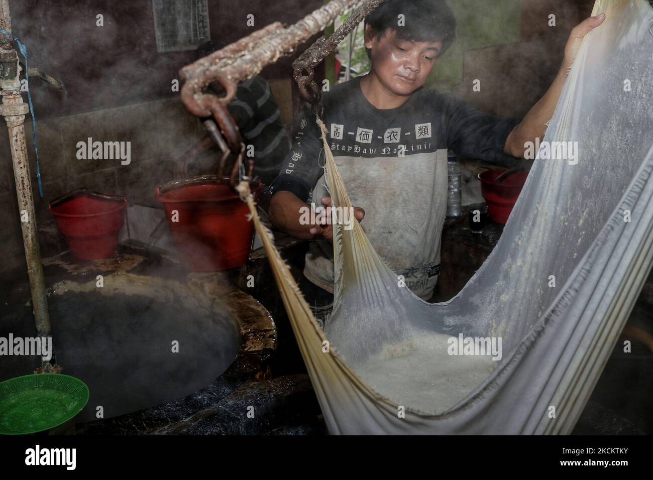 Un lavoratore elabora la soia importata dagli Stati Uniti in tofu presso un'industria domestica, Malang, Giava Orientale, il 3 settembre 2021. Dati dal Ministero dell'Agricoltura, circa il 86,4% della domanda di soia in Indonesia proviene dalle importazioni. Fino al 2020 Badan Pusat Statistik (BPS-Statistics Indonesia) dati, le importazioni di soia in Indonesia sono di 2,11 milioni di tonnellate. Il valore della transazione è di US$ 842,7 milioni o circa Rp 11,79 trilioni di dollari (ipotizzando un tasso di cambio di Rp. 14.000 per dollaro USA). In quel periodo, le maggiori importazioni di soia provenivano dagli Stati Uniti a 1,92 milioni di tonnellate, per un valore di 762,3 milioni di dollari americani Foto Stock