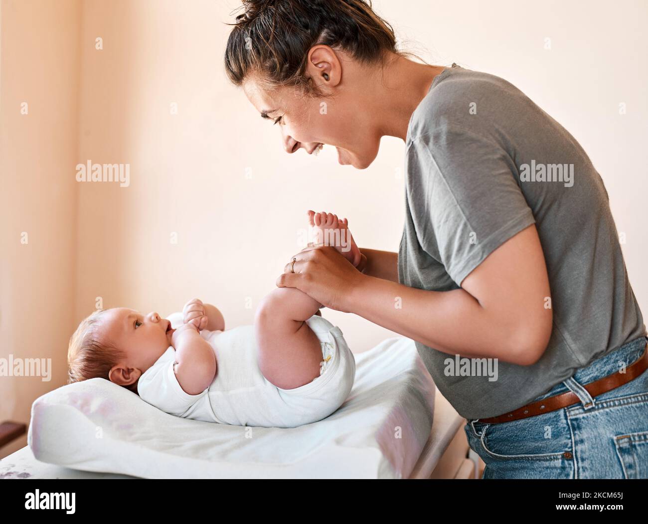 Ciao angelo, una giovane donna che si lega al suo bambino a casa. Foto Stock