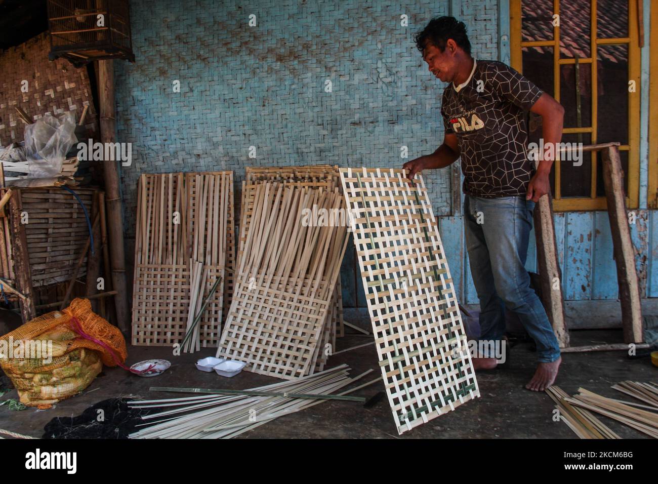 Un uomo che fa vassoi per le foglie di tabacco il 09 settembre 2021 nel villaggio di tabacco, Sumedang Regency, Indonesia. La maggior parte dei residenti in questo villaggio lavora come coltivatori di tabacco, una professione che hanno trasmesso sopra di generazione in generazione. Quando visitiamo questo villaggio, vedremo le distese di tabacco che asciugano sotto il sole che riempiono le strade del villaggio, i tetti e le terrazze delle case. Questo villaggio è in grado di soddisfare la domanda di mercato da tutte le province indonesiane tra cui West Java, Bali e Sumatra. Alcuni prodotti vengono persino esportati all'estero, in luoghi come il Pakistan, la Malesia e la Turchia. L'industria del tabacco in Foto Stock