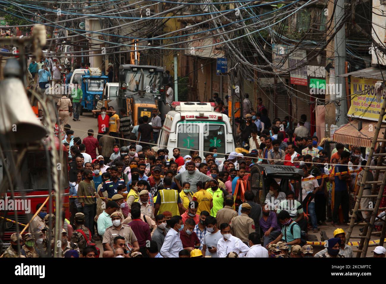 La gente guarda le operazioni di salvataggio dopo che un edificio a quattro piani è crollato nei pressi della zona di Subzi Mandi, a Nuova Delhi, in India, il 13 settembre 2021. (Foto di Mayank Makhija/NurPhoto) Foto Stock