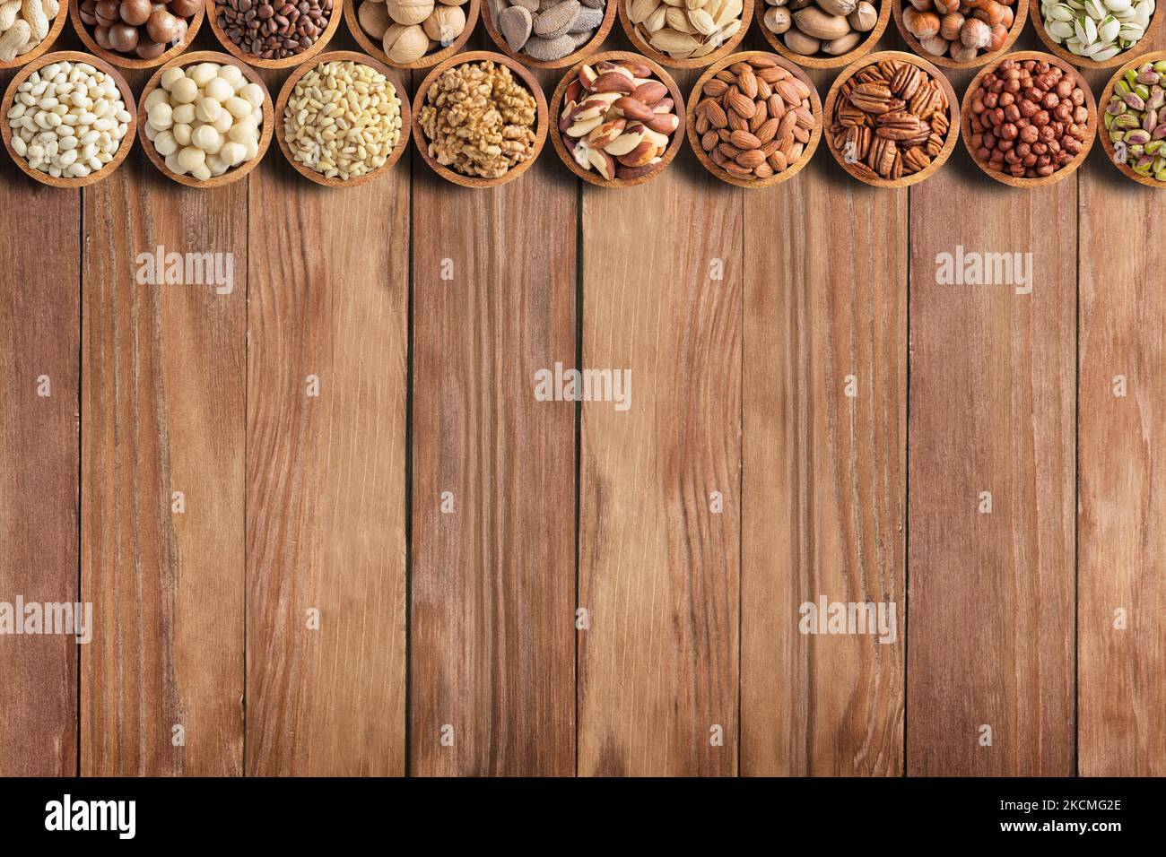 frutta secca e semi vari su tavola di legno con spazio copia. cibo sano sfondo Foto Stock