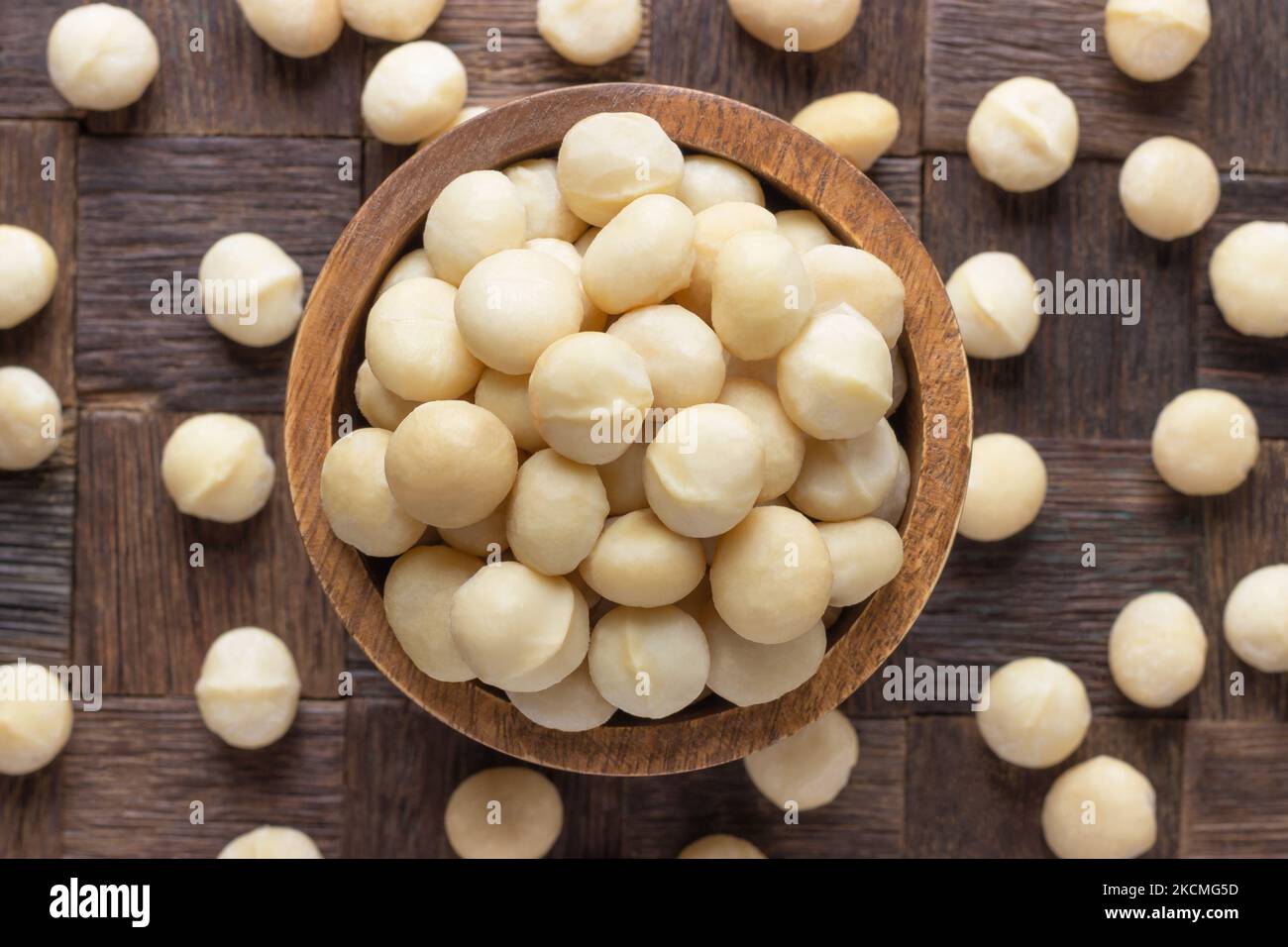 ciotola di peeledin di noci di macadamia su fondo di tavolo di legno. Foto Stock