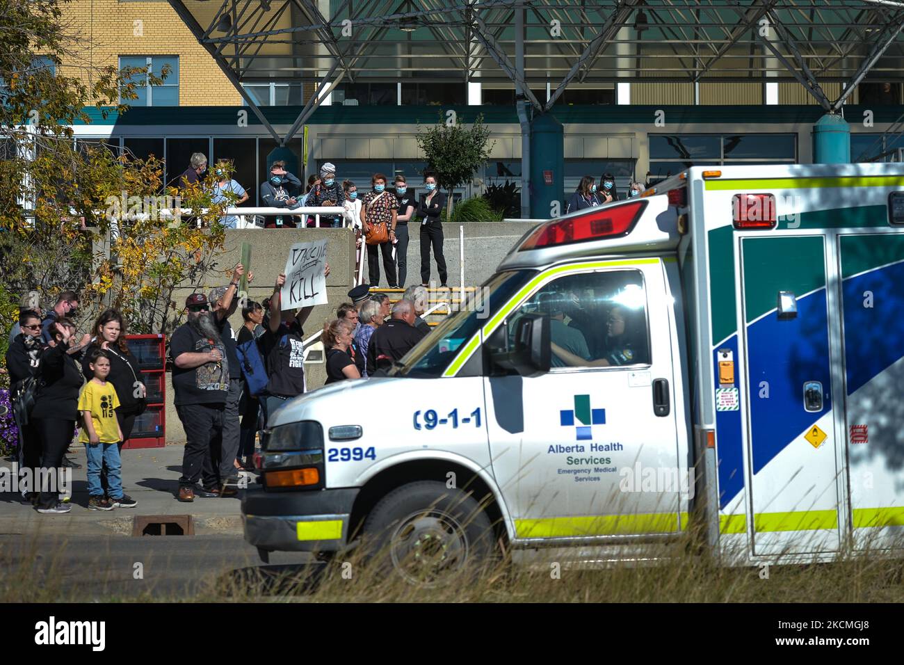 Un'ambulanza passa da un gruppo di manifestanti contro i vaccini obbligatori COVID-19, i passaporti e le misure di salute pubblica visti fuori dal Royal Alexandra Hospital di Edmonton. Le proteste odierne contro gli ordini di vaccinazione e altre misure di sanità pubblica relative al COVID-19, tenutesi oggi di fronte agli ospedali in tutto il Canada, sono state condannate da politici e organizzazioni sanitarie come inaccettabili e ingiuste per il personale e i pazienti. Lunedì 13 settembre 2021, a Edmonton, Alberta, Canada. (Foto di Artur Widak/NurPhoto) Foto Stock