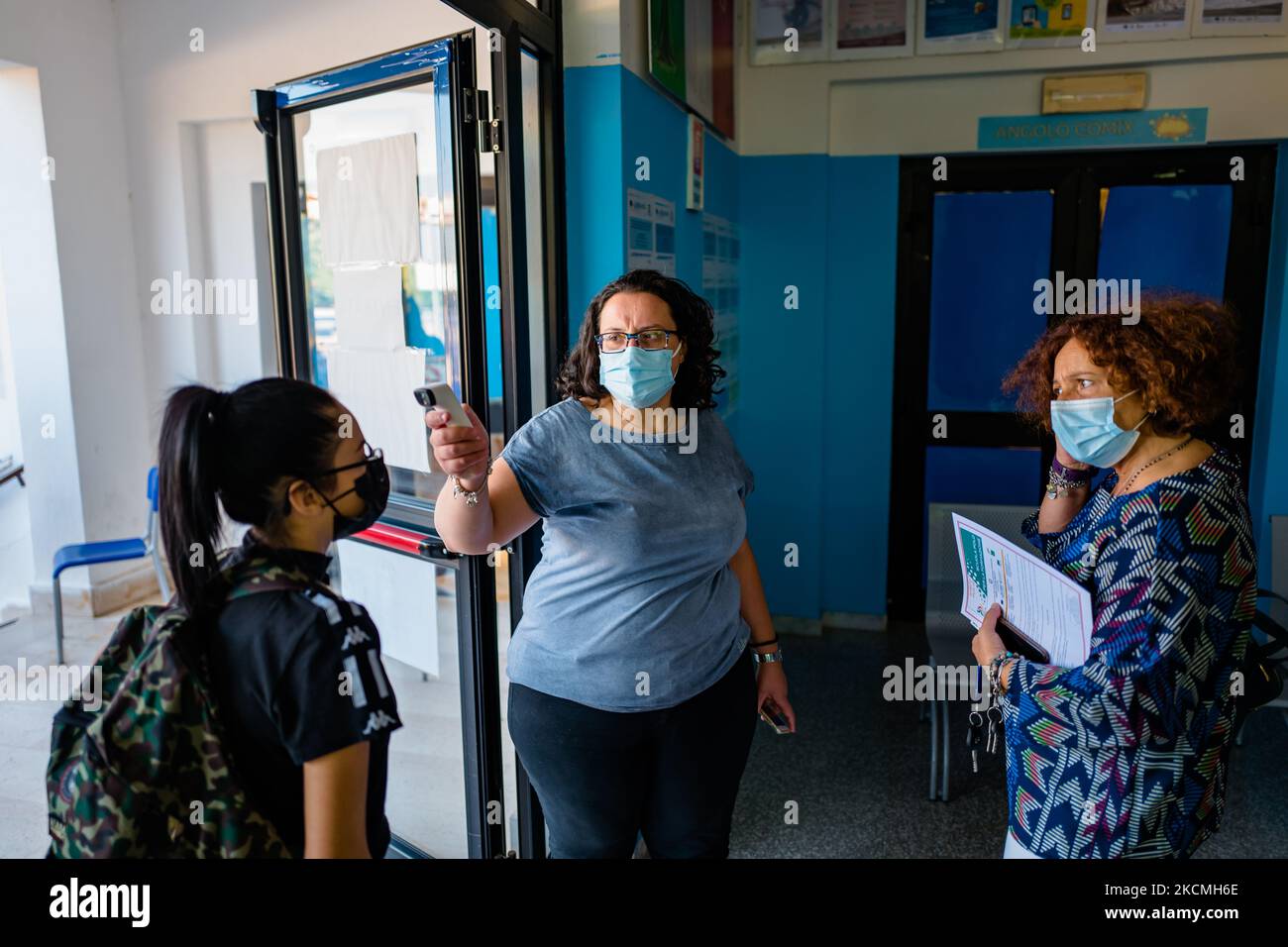 Collaboratore scolastico dell'Istituto superiore Mons. Antonio bello a Molfetta misura la temperatura degli studenti il primo giorno di scuola a Molfetta, Italia, il 14 settembre 2021. Ingressi scaglionati, doppi turni, pass verde obbligatorio per il personale scolastico, genitori in classe solo con pass, distanze più flessibili in classe. Il ritorno in classe è iniziato il 13 settembre per 3,9 milioni di studenti provenienti da dieci regioni del paese, mentre gli altri 3,5 milioni di alunni inizieranno il nuovo anno scolastico scaglionato secondo i calendari regionali, fino al 20 settembre (gli ultimi Puglia e Calabria). Il terzo Foto Stock