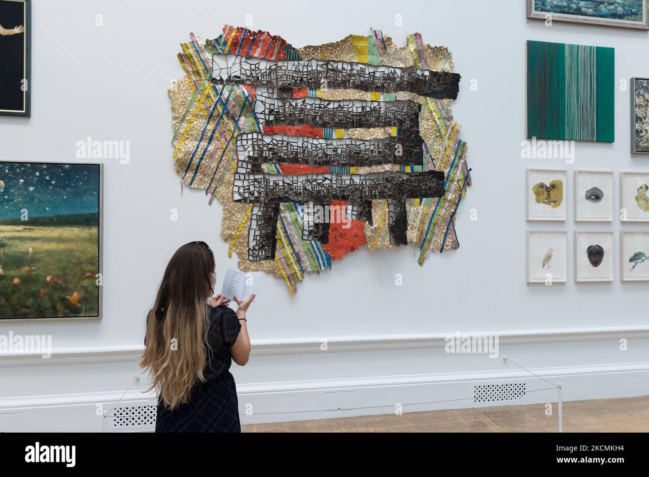LONDRA, REGNO UNITO - 15 SETTEMBRE 2021: Un membro dello staff della galleria guarda la 'Dexterity' di El Anatsui durante un'anteprima stampa della 253rd Summer Exhibition alla Royal Academy of Arts il 15 settembre 2021 a Londra, Inghilterra. La mostra, che si svolge in autunno tra il 22 settembre 2021 e il 2 gennaio 2022, comprende circa 1400 opere in una vasta gamma di media, dai grandi dipinti e sculture alla fotografia, stampe e tessuti di artisti emergenti e affermati. (Foto di Wiktor Szymanowicz/NurPhoto) Foto Stock LONDRA, REGNO UNITO - 15 SETTEMBRE 2021: Un membro dello staff della galleria guarda la 'Dexterity' di El Anatsui durante un'anteprima stampa della 253rd Summer Exhibition alla Royal Academy of Arts il 15 settembre 2021 a Londra, Inghilterra. La mostra, che si svolge in autunno tra il 22 settembre 2021 e il 2 gennaio 2022, comprende circa 1400 opere in una vasta gamma di media, dai grandi dipinti e sculture alla fotografia, stampe e tessuti di artisti emergenti e affermati. (Foto di Wiktor Szymanowicz/NurPhoto) Foto Stock