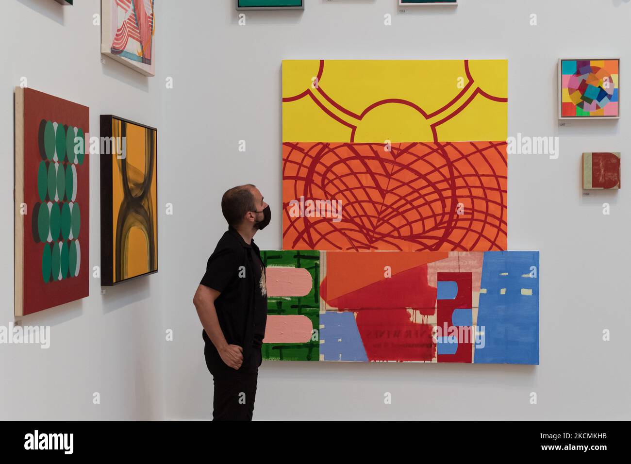 LONDRA, REGNO UNITO - 15 SETTEMBRE 2021: Un membro dello staff della galleria guarda la "sedia rossa" di Stephen Cooper durante un'anteprima stampa della mostra estiva 253rd alla Royal Academy of Arts il 15 settembre 2021 a Londra, Inghilterra. La mostra, che si svolge in autunno tra il 22 settembre 2021 e il 2 gennaio 2022, comprende circa 1400 opere in una vasta gamma di media, dai grandi dipinti e sculture alla fotografia, stampe e tessuti di artisti emergenti e affermati. (Foto di Wiktor Szymanowicz/NurPhoto) Foto Stock LONDRA, REGNO UNITO - 15 SETTEMBRE 2021: Un membro dello staff della galleria guarda la "sedia rossa" di Stephen Cooper durante un'anteprima stampa della mostra estiva 253rd alla Royal Academy of Arts il 15 settembre 2021 a Londra, Inghilterra. La mostra, che si svolge in autunno tra il 22 settembre 2021 e il 2 gennaio 2022, comprende circa 1400 opere in una vasta gamma di media, dai grandi dipinti e sculture alla fotografia, stampe e tessuti di artisti emergenti e affermati. (Foto di Wiktor Szymanowicz/NurPhoto) Foto Stock
