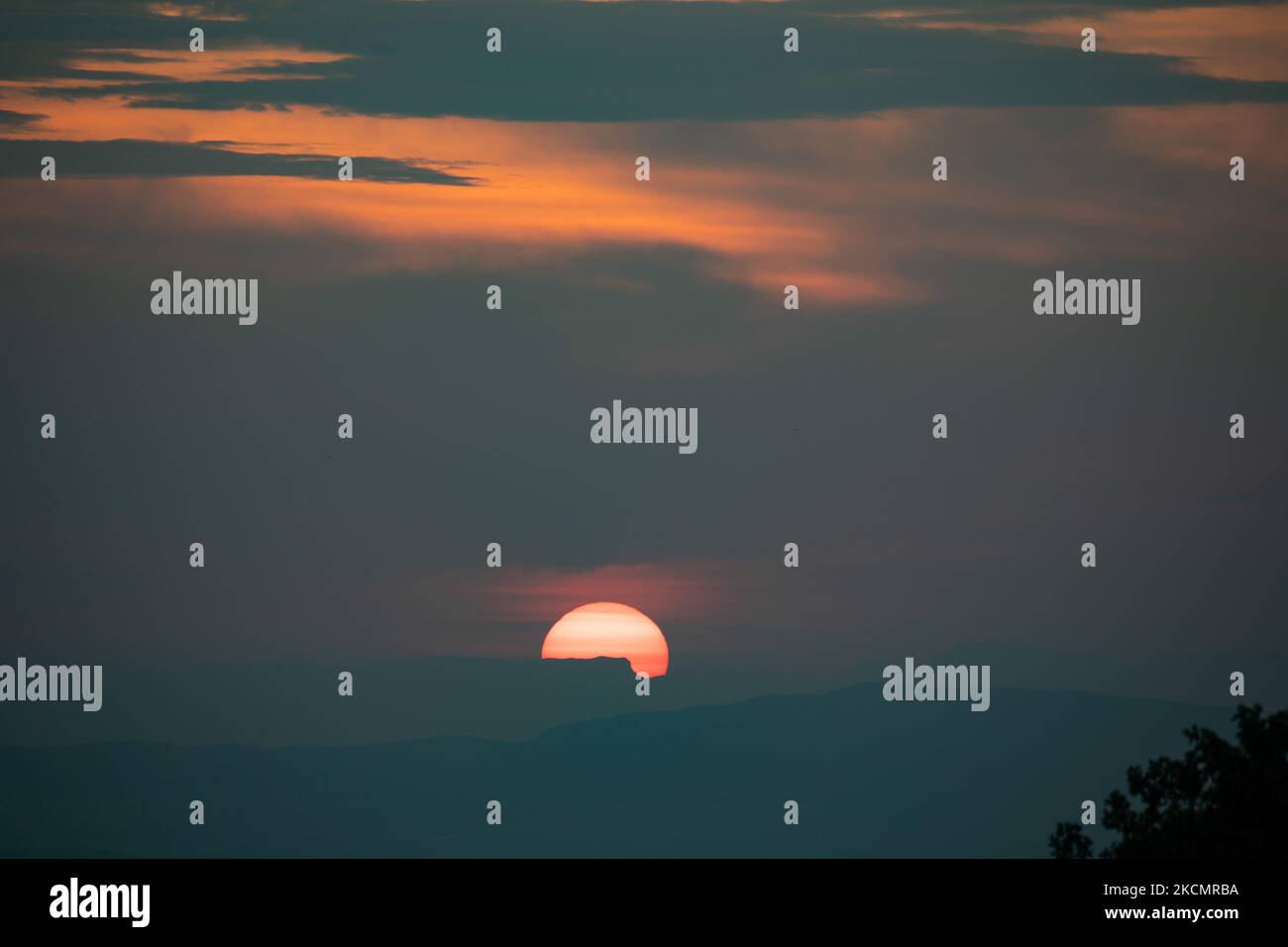 Tramonto con cielo colorato e nuvole. Il sole tramonta dietro le montagne sopra la città di Volos, come si vede dalla montagna di Pelion tra Portaria e il villaggio di Makrinitsa. Portaria, Grecia il 17 settembre 2021 (Foto di Nicolas Economou/NurPhoto) Foto Stock