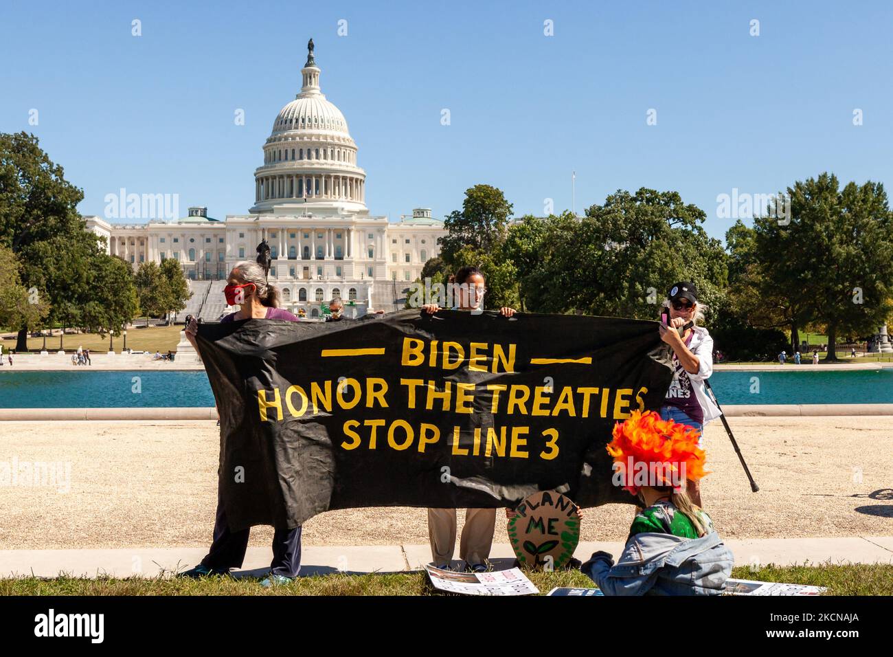 Gli attivisti hanno una bandiera che esorta il presidente Biden a fermare l'oleodotto della linea 3, di fronte al pool riflettente sul Campidoglio degli Stati Uniti durante uno sciopero climatico globale del venerdì per il futuro. Il venerdì per il futuro è un'organizzazione globale guidata dai giovani fondata da Greta Thunberg e dagli sciatori scolastici in Svezia nel 2018. Più di un centinaio di ragazzi hanno partecipato alla protesta a Washington. (Foto di Allison Bailey/NurPhoto) Foto Stock