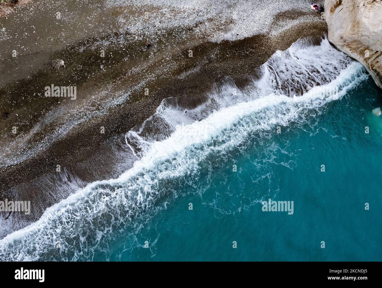 Drone aereo di costa rocciosa con onde di mare che colpiscono la riva. Mare dall'alto. Rocca di Afrodite Paphos Cipro Rocca di Afrodite Paphos Cipro Foto Stock