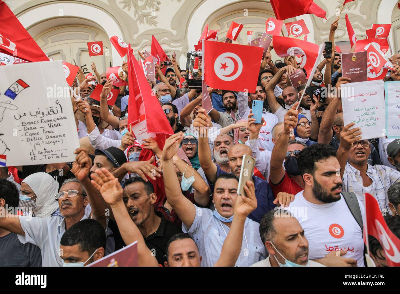 I manifestanti sollevano copie della costituzione tunisina del 2014 mentre fanno sventolare le bandiere tunisine mentre gridano a Dégage, , durante una manifestazione svoltasi in Avenue Habib Bourguiba a Tunisi, in Tunisia, il 26 settembre 2021, per protestare contro ciò che migliaia di manifestanti hanno chiamato colpo di stato, Riferendosi alle nuove misure eccezionali decretate dal Presidente della Tunisia, Kais Saied e pubblicate sulla Gazzetta ufficiale. Alcuni giorni prima, Kais Saied ha annunciato la continuazione del congelamento del Parlamento e la promulgazione di misure eccezionali per l'esercizio del potere legislativo e di quello esecutivo. Lui Foto Stock