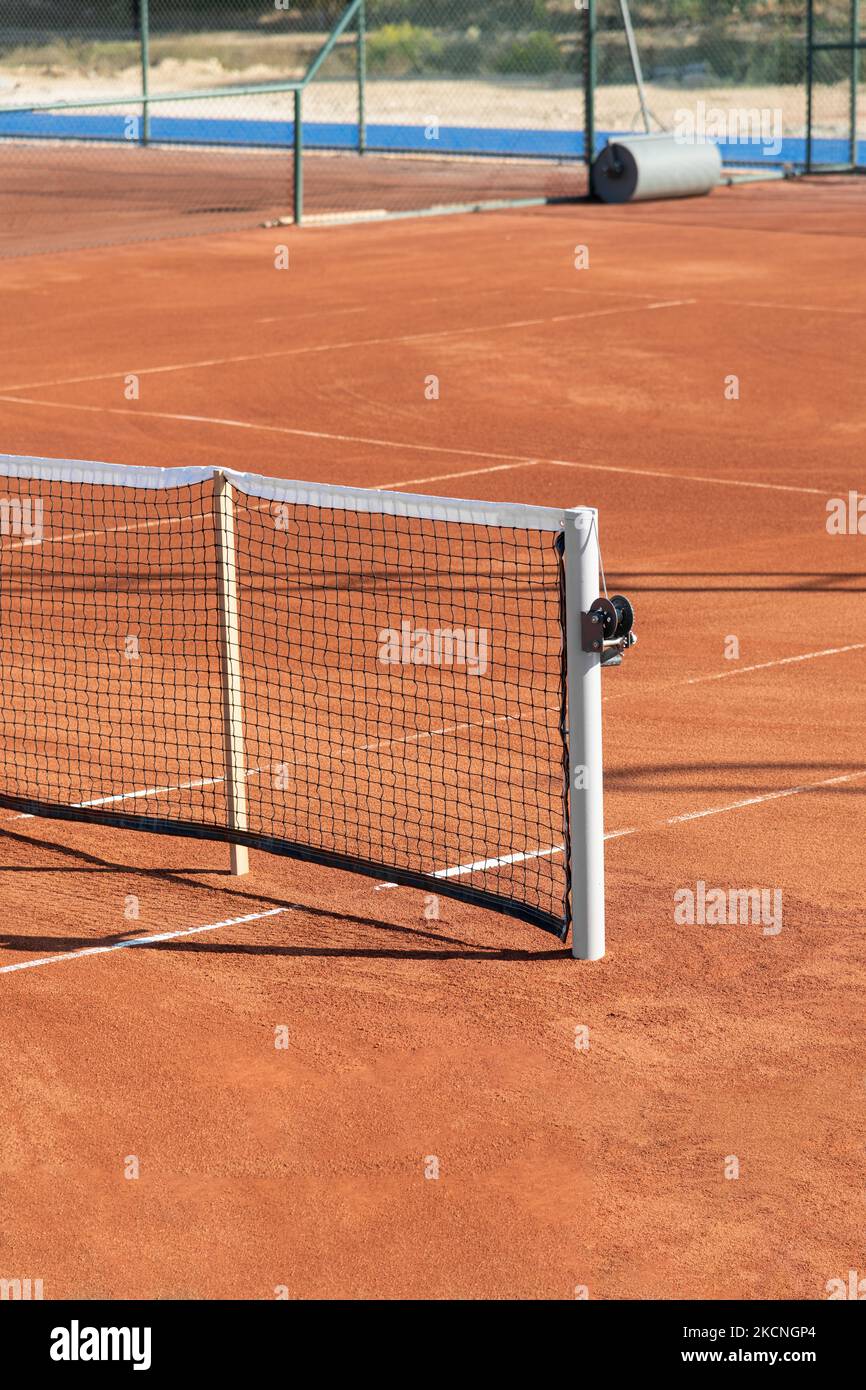 Baseline e al netto di un campo da tennis in terra battuta in una giornata di sole Foto Stock