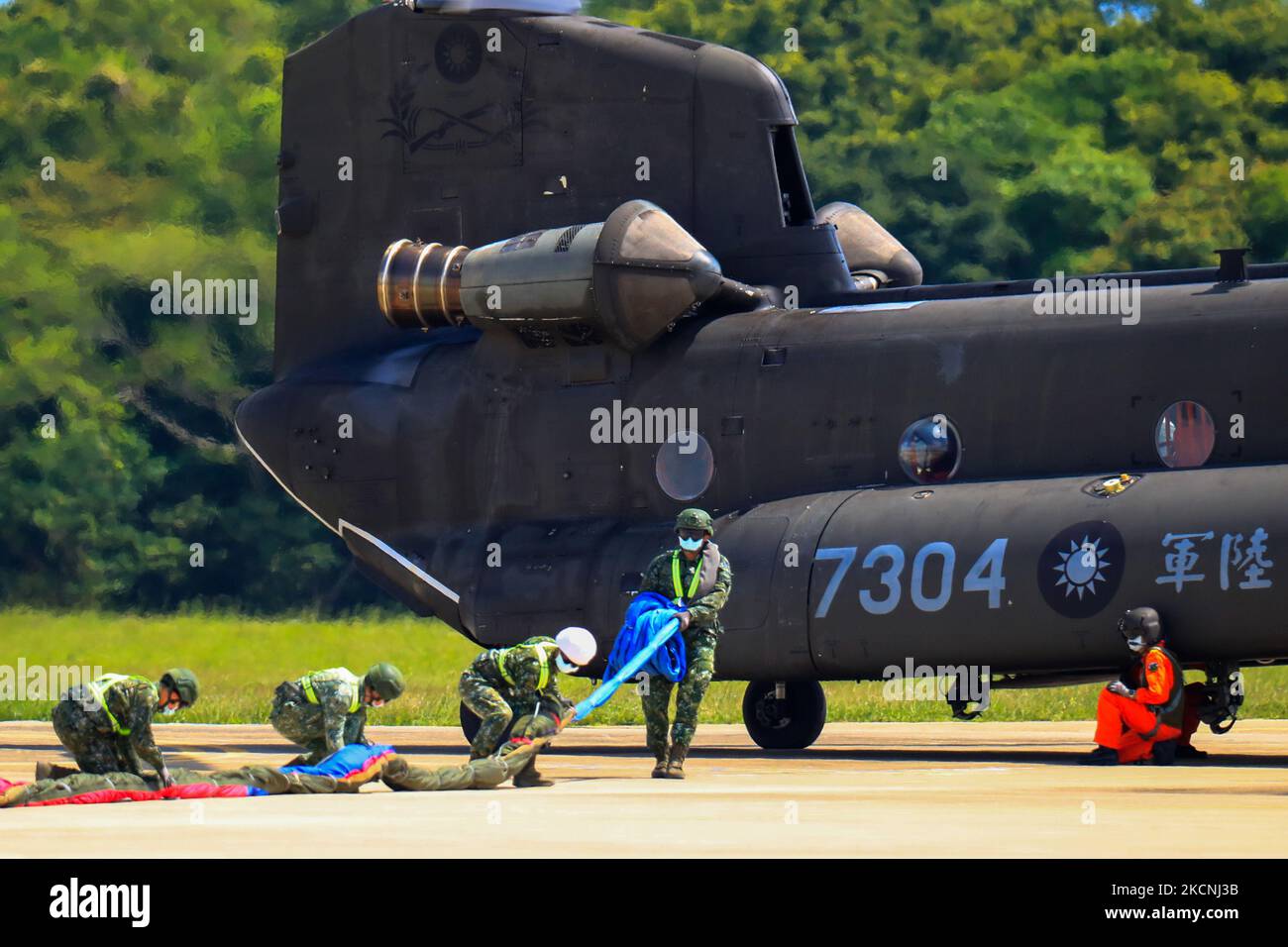 Ufficiali militari appendono la più grande bandiera di Taiwan su un elicottero chinook in un campo militare, come parte di una prova per la performance flyby della Double-Ten National Day Celebration di Taiwan, tra le crescenti tensioni tra Pechino e Taipei e le minacce provenienti dalla Cina, a Taoyuan, Taiwan, 28 settembre 2021. La bandiera taiwanese larga 18 metri e lunga 12 metri, secondo l'agenzia di stampa centrale dello stato, sarà portata da due elicotteri CH-47 Chinook che battono bandiera sull'Ufficio presidenziale, oltre a una sfilata con i sistemi missilistici dell'isola che mostreranno l'abilit delle forze armate Foto Stock