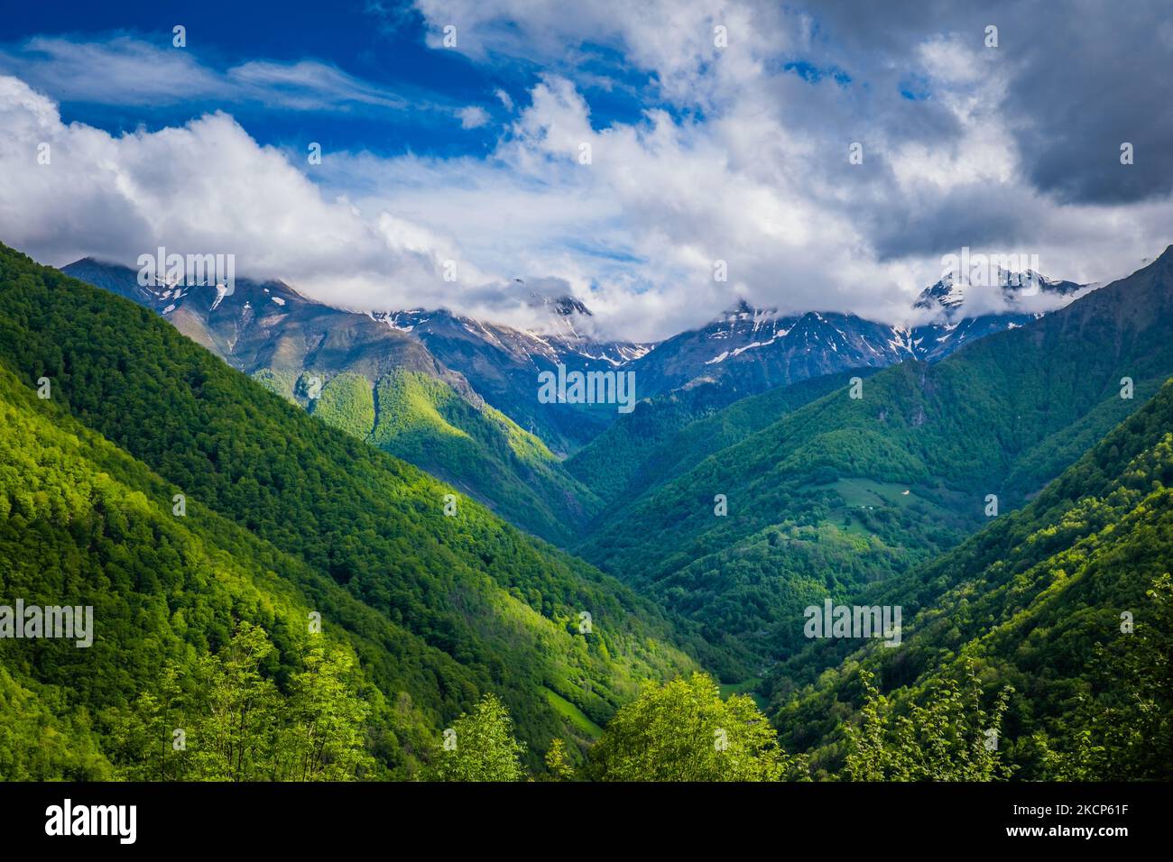 Vista sulla valle del fiume Lez con cime innevate sullo sfondo in una bella giornata estiva nella catena montuosa dei Pirenei francesi Foto Stock