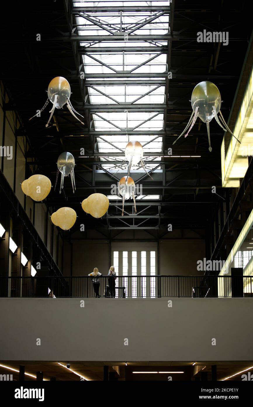 Aerobi riempiti di elio e a rotore che formano l'artista Anicka Yi 'in Love with the World' che galleggia intorno alla sala turbine della galleria d'arte moderna Tate alla presentazione dell'opera, l'ultima della serie della Commissione Hyundai, a Londra, in Inghilterra, il 11 ottobre 2021. Le macchine galleggianti hanno lo scopo di "spingere gli spettatori a pensare a nuovi modi in cui le macchine potrebbero abitare nel mondo", e formano la sesta Commissione Hyundai di opere annuali create da artisti appositamente per la sala turbine. L'installazione verrà eseguita fino al 16 gennaio del prossimo anno. (Foto di David Cliff/NurPhoto) Foto Stock