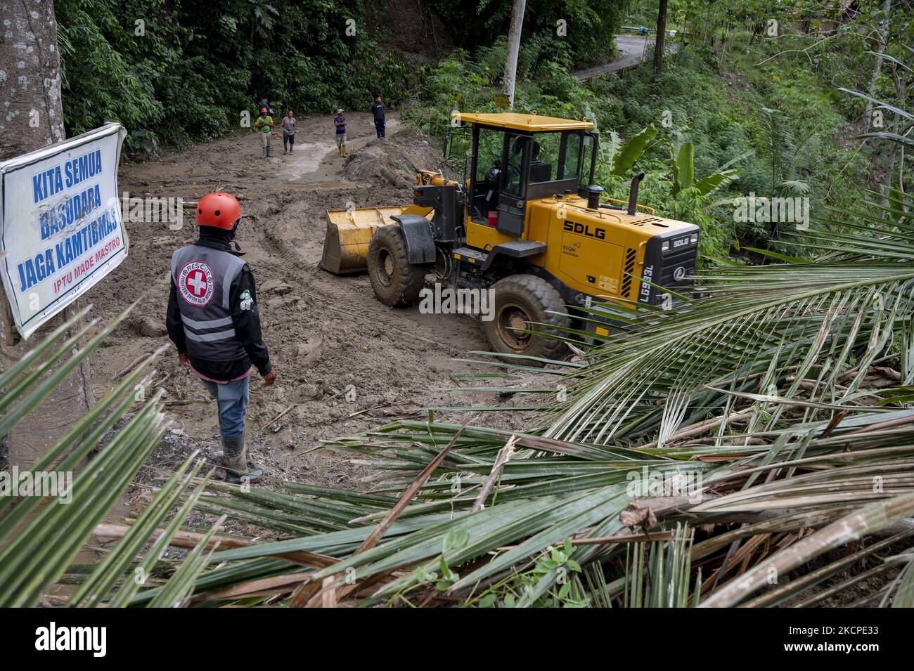 Gli operatori delle attrezzature pesanti rimuovono il materiale che ha bloccato la strada Trans Palu-Kulawi a causa di inondazioni e frane improvvise nel villaggio di Salua, distretto di Kulawi, reggenza di Sigi, provincia di Sulawesi centrale, Indonesia il 11 ottobre 2021. L'alluvione che si è verificata il 10 ottobre 2021 notte a causa di forti piogge ha causato decine di case gravemente danneggiate, e ben 42 capi di famiglie sono stati costretti a fuggire in luoghi sicuri, tra cui le chiese locali. In precedenza, l'agenzia locale di meteorologia, climatologia e geofisica (BMKG) aveva avvertito di un potenziale disastro con previsioni di pioggia e forti venti in Seve Foto Stock