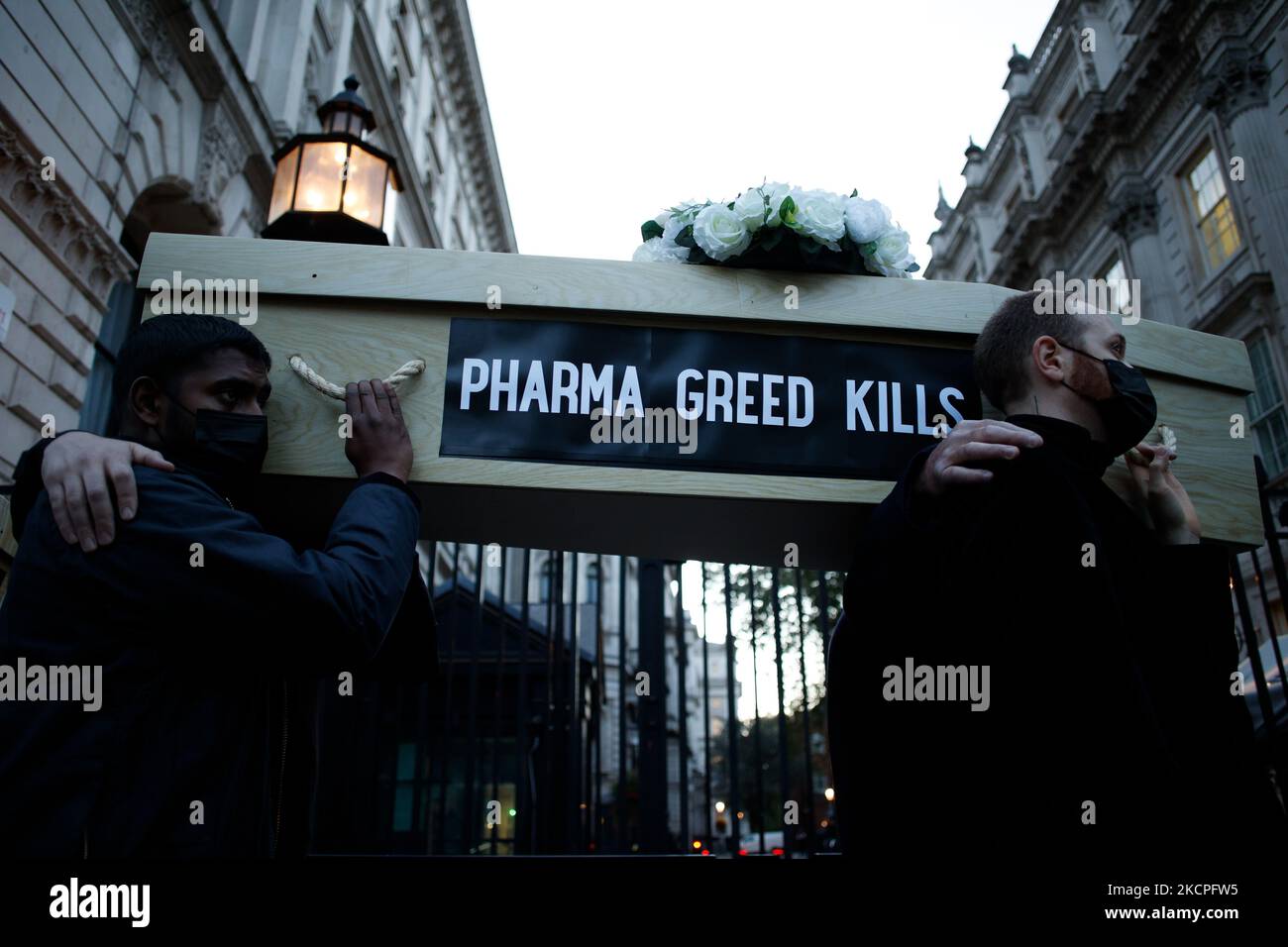 I membri del gruppo attivista Global Justice Adesso che si batte per le aziende farmaceutiche per sospendere i brevetti sui vaccini covid-19 trasportano bare fittizie fuori dalle porte di Downing Street durante una "marcia funeraria" da Parliament Square a Londra, Inghilterra, il 12 ottobre 2021. La giustizia globale ora ha citato il Regno Unito per le critiche per essersi opposto alle proposte di sospensione dei brevetti del 19 presso l’Organizzazione mondiale del commercio. La sospensione dei brevetti contenderebbe "permettere al mondo di accelerare la produzione” di vaccini covid-19 e di evitare uno stato di "apartheid vaccino” che si sviluppa tra paesi ricchi e poveri. Foto Stock