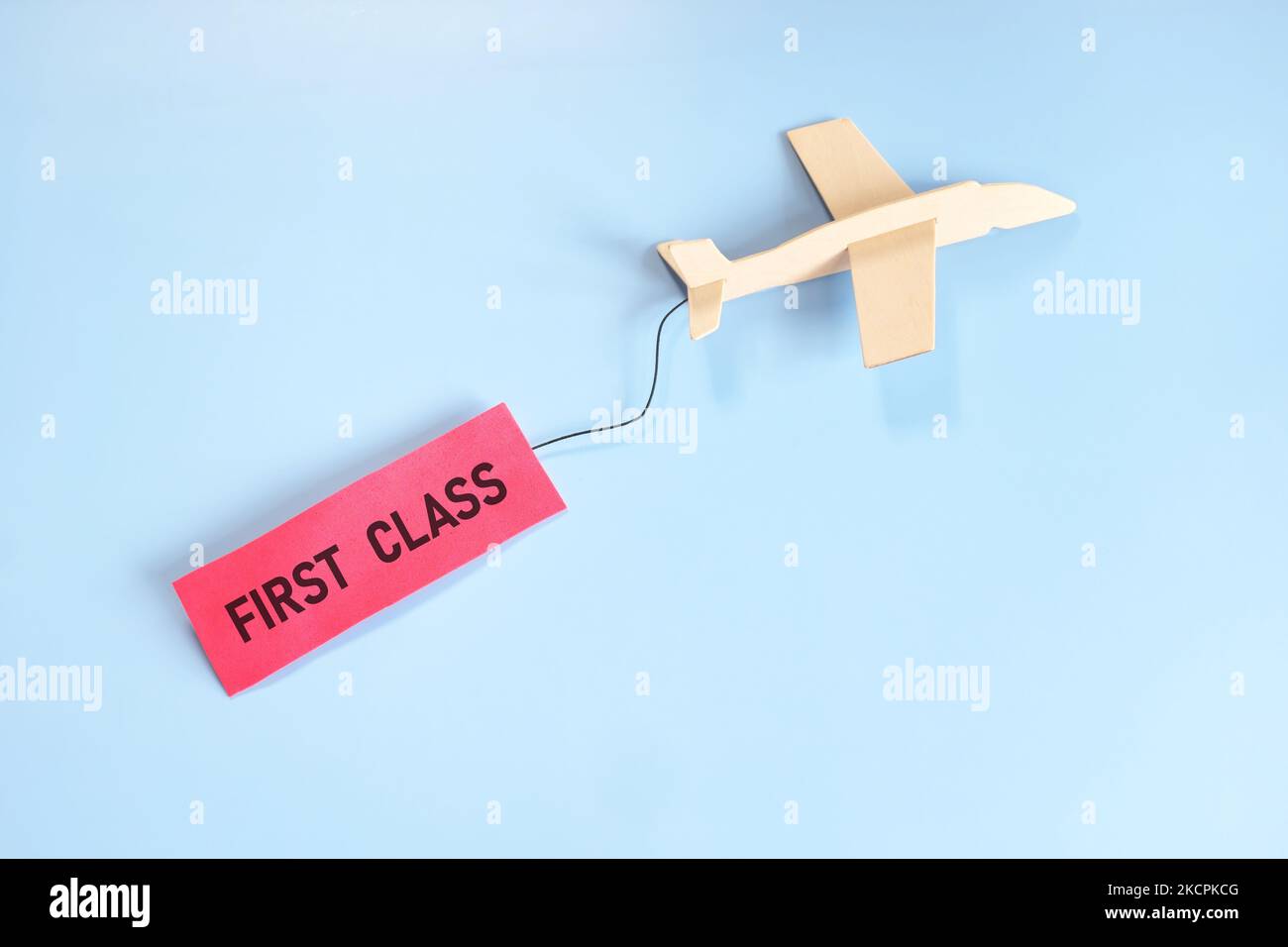Concetto di biglietto di prima classe Fly. Aereo commerciale modello in legno con etichetta rossa classe business. Foto Stock