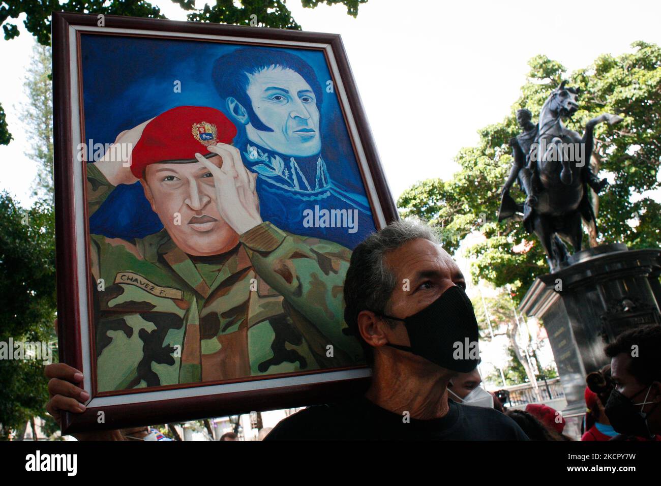 Un uomo tiene una foto del defunto presidente Hugo Chavez accompagnato dal liberatore Simon Bolivar durante un raduno di solidarietà con l'uomo d'affari colombiano in seguito alla sua estradizione negli Stati Uniti da Capo Verde in mezzo alla pandemia di Coronavirus a Caracas, Venezuela 17 ottobre 2021. (Foto di Javier Campos/NurPhoto) Foto Stock