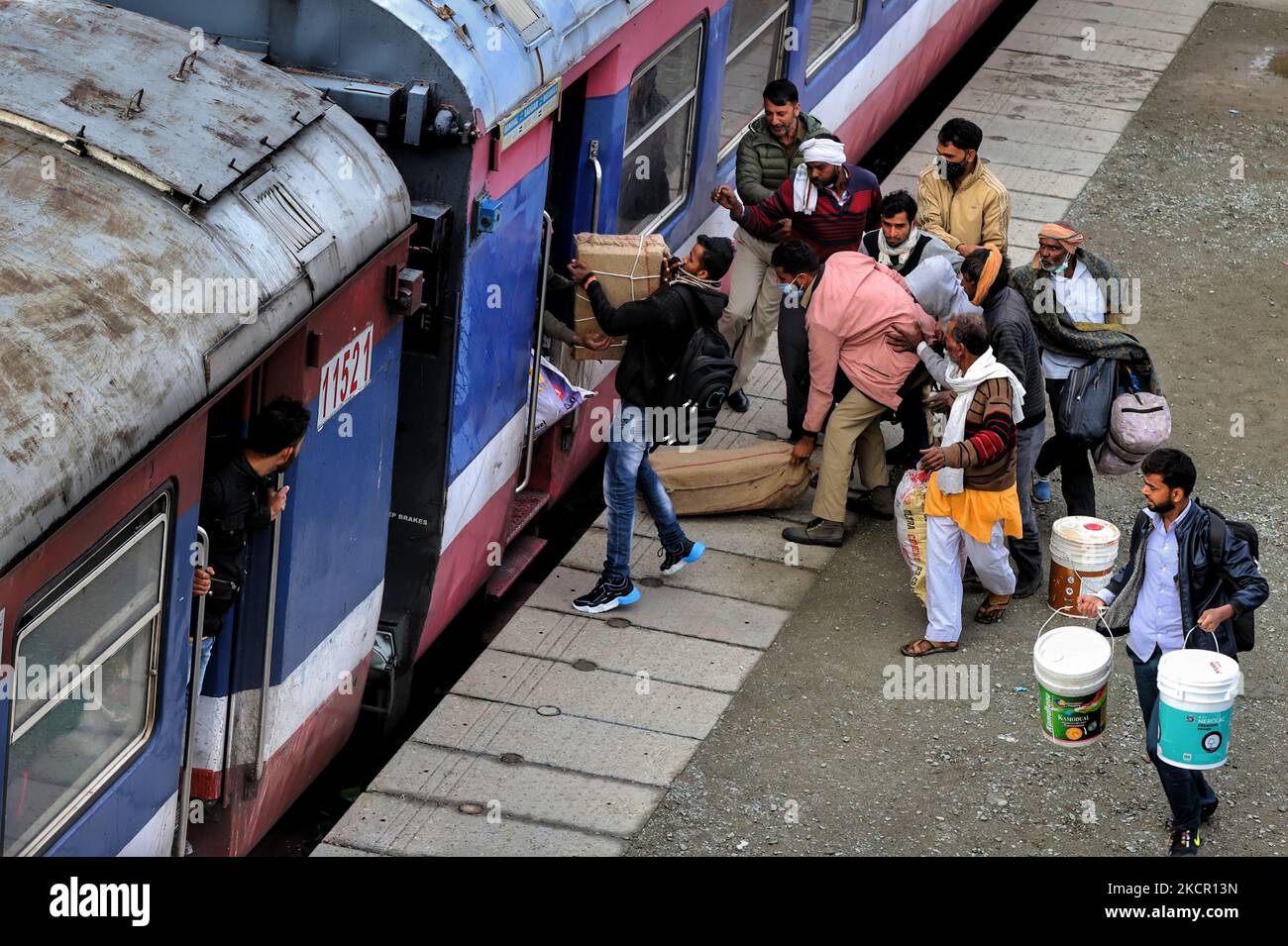 I lavoratori migranti indiani salgono a bordo di un treno su una piattaforma ferroviaria mentre partono per i loro stati d'origine a seguito degli attacchi contro i lavoratori migranti da parte di militanti sospetti nel Kashmir, alla periferia di Sopore, nel distretto di Baramulla, Jammu e Kashmir, in India, il 19 ottobre 2021. Centinaia di operai che sono venuti a trovare lavoro hanno cominciato a fuggire dalla regione il lunedì, prendendo il treno 1st da Sopore a Banihal per il viaggio in toÂ KashmirÂ altri stati. (Foto di Nasir Kachroo/NurPhoto) Foto Stock