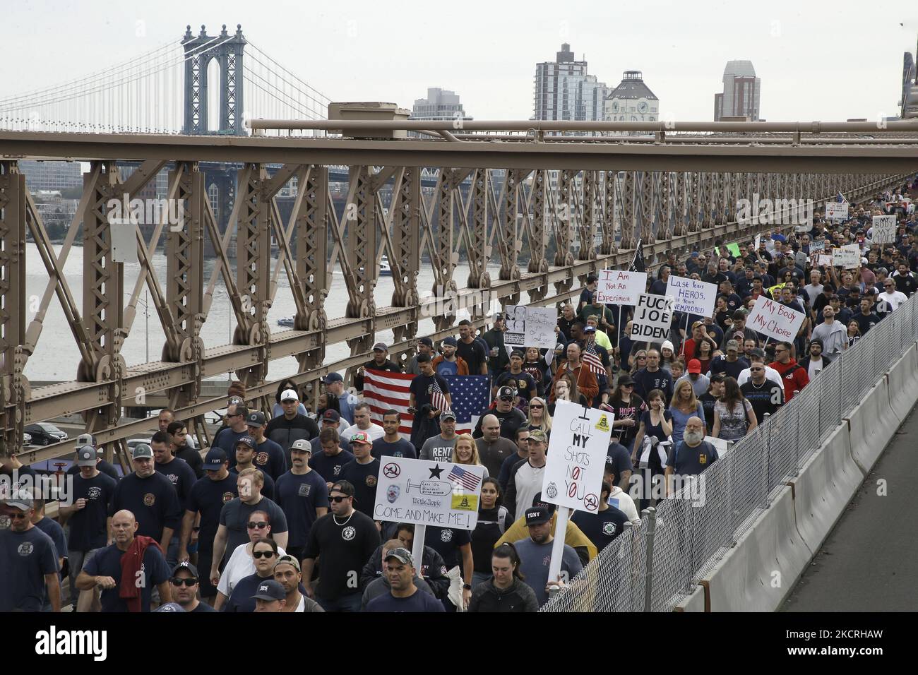 Migliaia di lavoratori cittadini marciano attraverso il Ponte di Brooklyn mentre il mandato del sindaco di New York Bill de Blasio per il vaccino incombe pochi giorni prima della scadenza, il 25 ottobre 2021 a New York City, USA. Il mandato di fine settimana di De Blasio stabilisce che i lavoratori delle città dovranno essere licenziati se non si conformano ad almeno una dose di vaccino anti-Covid-19. Dopo la marcia i manifestanti si sono riuniti vicino al Municipio, dove hanno cantato slogan anti-De Blasio e hanno mostrato solidarietà tra tutti i lavoratori della città. (Foto di John Lamparski/NurPhoto) Foto Stock