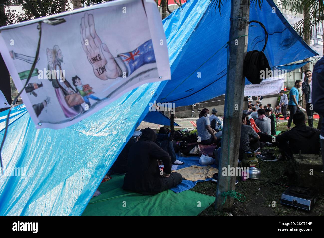 Gli uomini rifugiati afghani che vivono in Indonesia siedono nella loro tenda durante una protesta con la notte fuori dall'ufficio di rappresentanza dell'UNHCR il 2 novembre 2021 a Medan, Indonesia. I manifestanti sono rifugiati afghani, per lo più membri della minoranza etnica di Hazara, che chiedono al governo indonesiano di esortare le Nazioni Unite, l'UNHCR e l'OIM a inviare e a chiedere il reinsediamento in paesi terzi. (Foto di Ivan Damanik/NurPhoto) Foto Stock