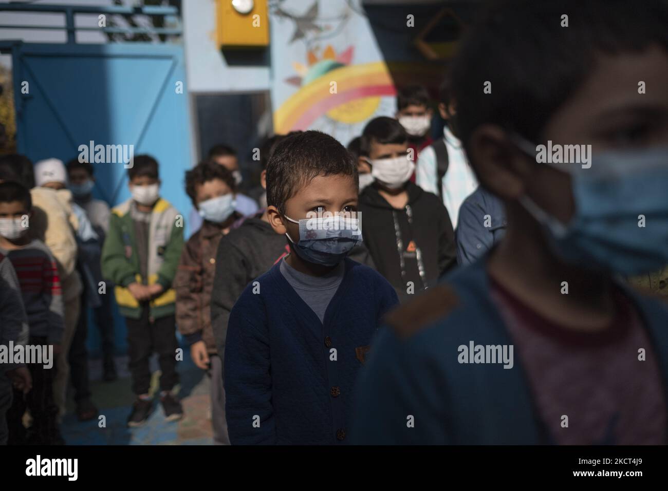 Gli studenti afghani rifugiati che indossano maschere protettive stanno alla scuola di Farhang nel primo giorno del nuovo anno accademico? Nel sud di Teheran il 1 novembre 2021. La scuola di Farhang è stata fondata nel 2000 dal rifugiato afgano Nader Mousavi che si è laureato in sociologia presso l'Università di Teheran, per i bambini rifugiati afghani, E ora due anni dopo l’inizio dell’epidemia COVID-19 in Iran, dove la scuola operava a tempo parziale, ha iniziato a funzionare a tempo pieno e le scolaresche e gli scolari afghani possono frequentare la scuola. Le famiglie non devono pagare i soldi per il tuitio Foto Stock