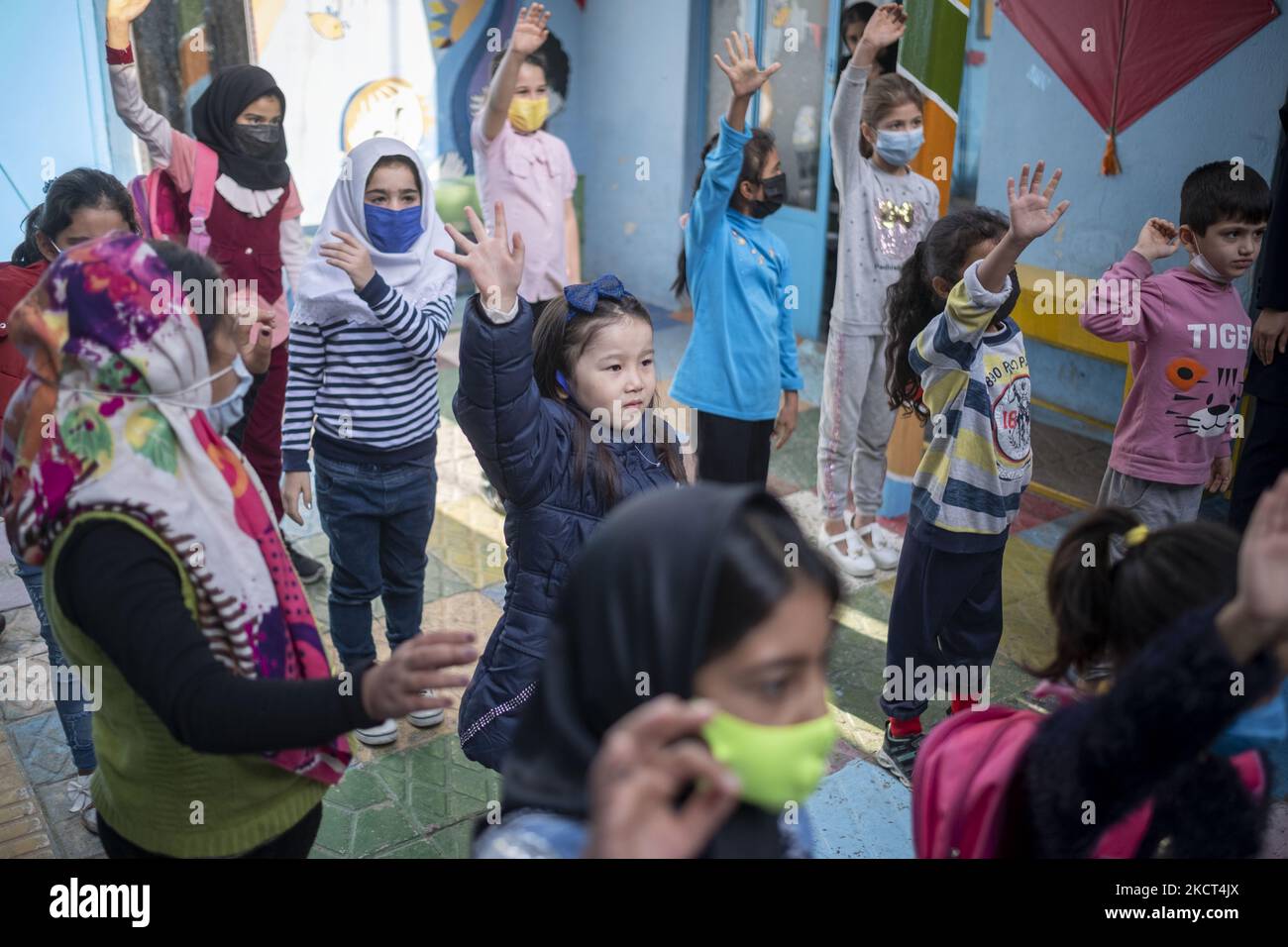 Le studentesse afghane rifugiate si esercitano alla scuola di Farhang nel primo giorno del nuovo anno accademico? Nel sud di Teheran il 1 novembre 2021. La scuola di Farhang è stata fondata nel 2000 dal rifugiato afgano Nader Mousavi che si è laureato in sociologia presso l'Università di Teheran, per i bambini rifugiati afghani, E ora due anni dopo l’inizio dell’epidemia COVID-19 in Iran, dove la scuola operava a tempo parziale, ha iniziato a funzionare a tempo pieno e le scolaresche e gli scolari afghani possono frequentare la scuola. Le famiglie non devono pagare i soldi per le tasse scolastiche perché sono gratuite per gli afghani Foto Stock